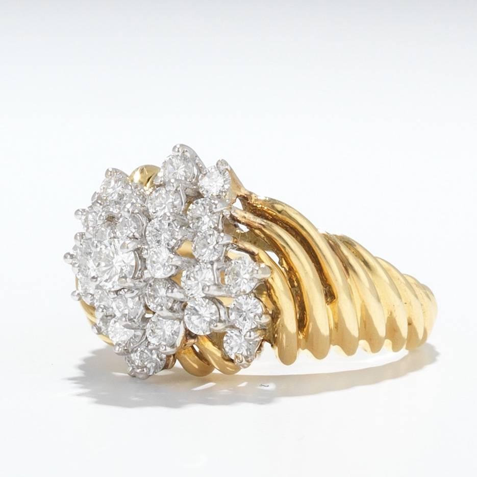 Lovely 18k yellow gold cocktail ring with reeded swirl shoulders, featuring a diamond cluster in the center.  Total estimated diamond weight is 1.40 carats of fine quality G/H VS diamonds.  The ring is a size 7 and is signed; HB 18k.  The overall