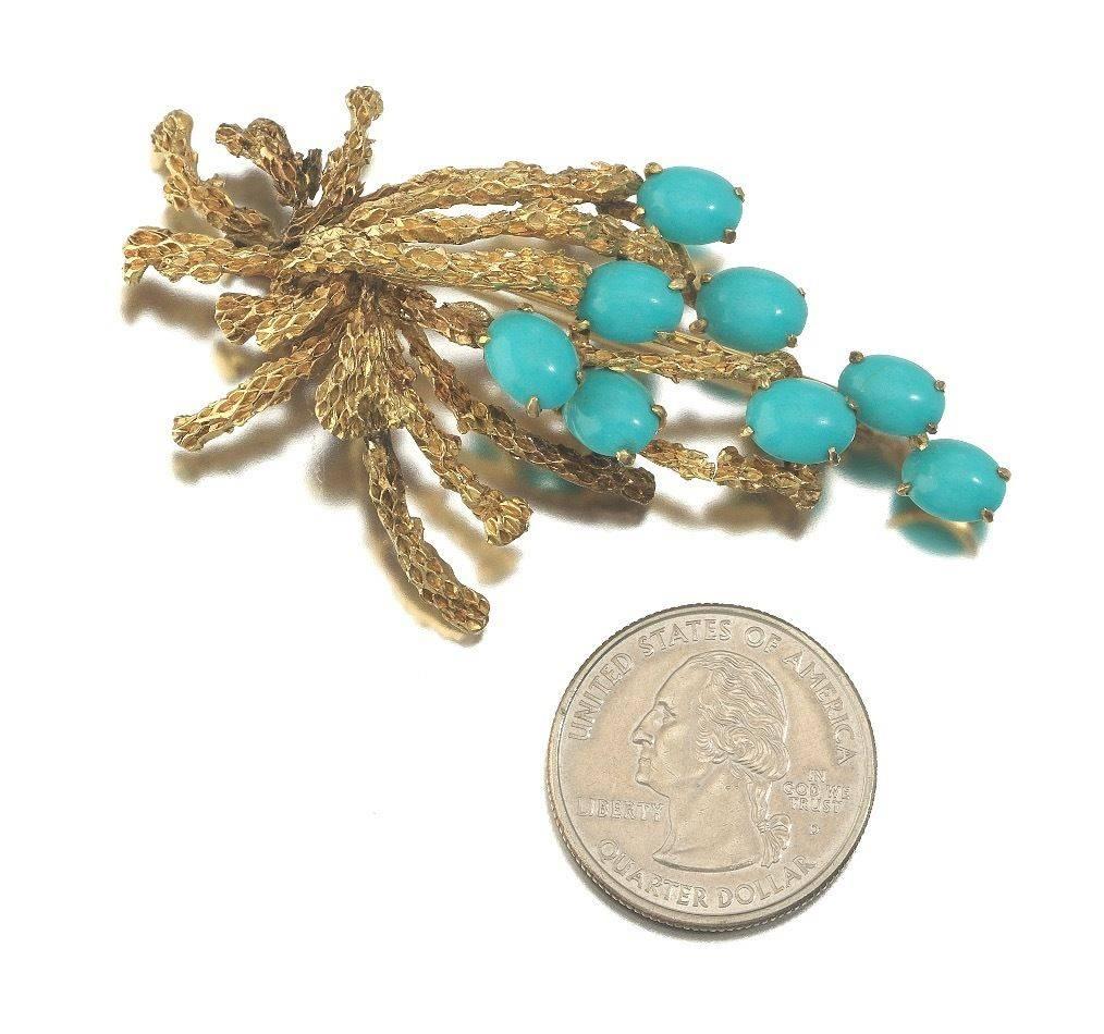 Striking vintage 14k yellow gold textured spray brooch, recently converted to a necklace pendant, is set with lovely oval turquoise color cabochons. The pendant measures 2 ½ x½ inches.   Stamped on the back plaque "14k Sena".  The overall
