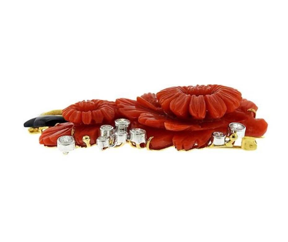 Striking large brooch set with a colorful assortment of carved floral red coral, black onyx, 18k gold and 1.65 carats of gem quality brilliant cut diamonds.  The brooch/pin is 58mm x 40mm at widest point.  It would make a stunning pendant for a