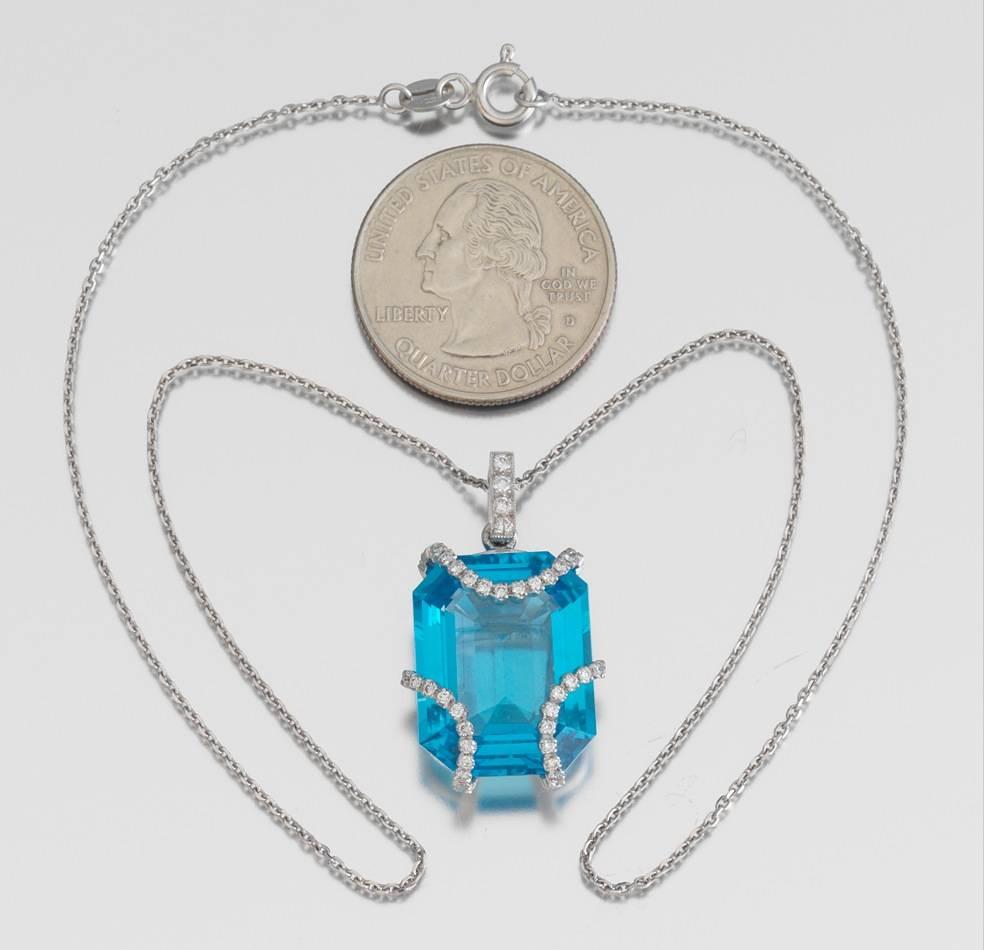 Striking Eli Frei designer necklace features a 18k white gold mounting accented with brilliant F/VS round cut diamonds and a large emerald cut topaz of stunning blue color.  The total diamond weight is 0.47 carats and the topaz weight is 11 carats. 