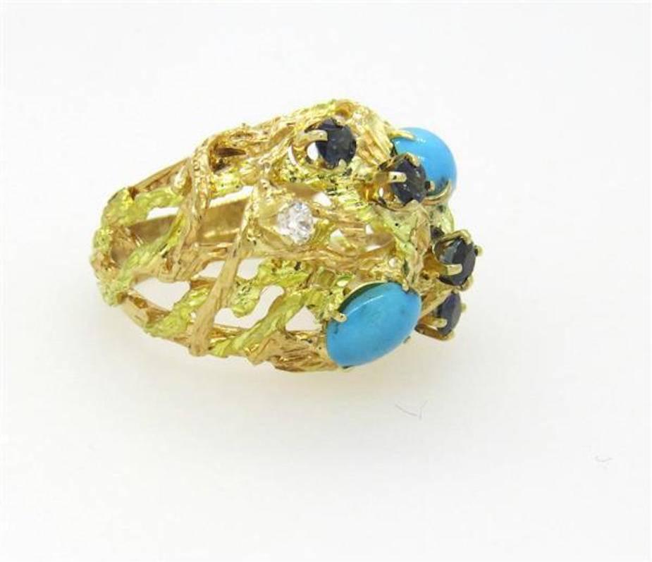 This impressive mid-century 1970s 18k gold free-form design ring features lovely gemstones: two Turquoise cabochons, four Sapphires and two diamonds.   There is 0.20 carats of H/VS/SI1 quality diamonds.  The ring is a size 7 and can be easily