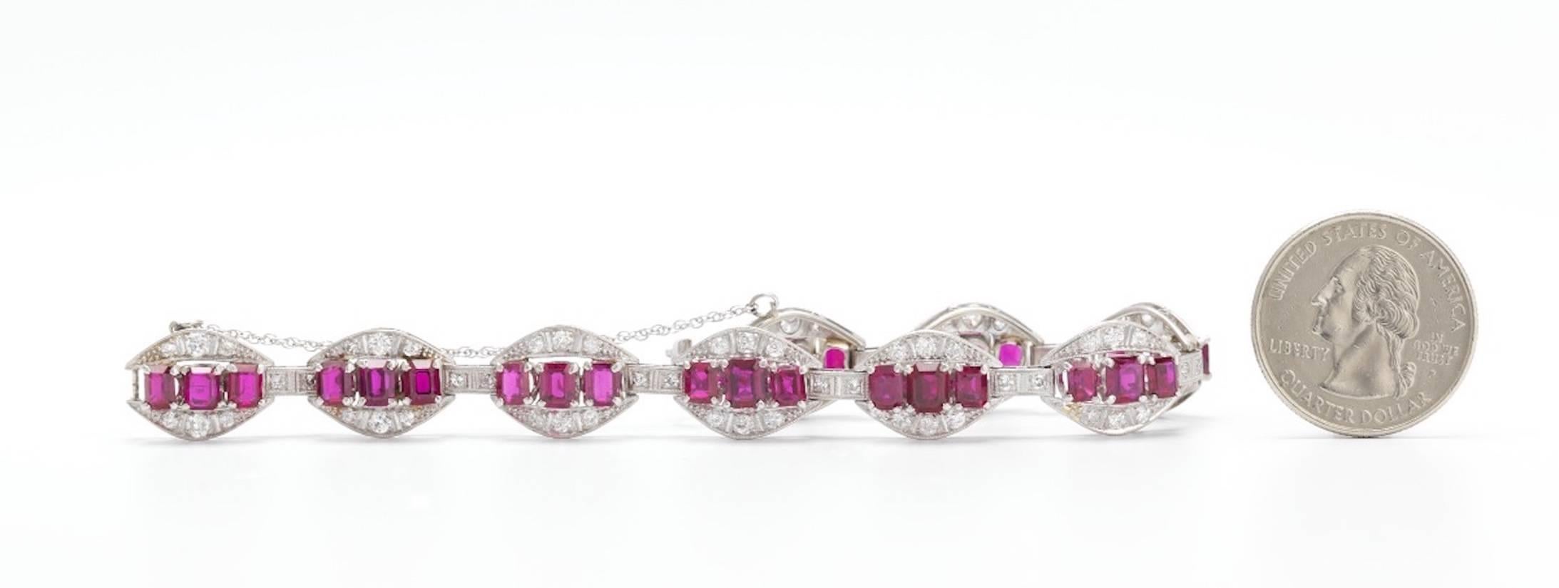 This impressive white gold ruby and diamond bracelet boasts an articulated design with oval links, each link set with emerald cut ruby, and further accentuated with round cut diamonds on top and bottom.  Each link is bracelet with a spacer set with