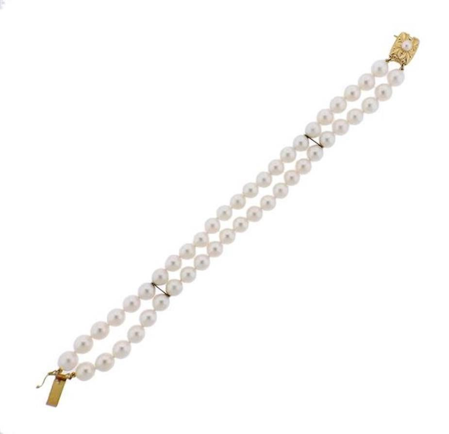 Stunning 18k yellow gold Mikimoto double strand cultured pearl bracelet is set with 7-7.5mm pearls.  Featuring a beautiful yellow gold clasp with a 4.4mm pearl set on it, and two gold bars.  The bracelet is fully marked "750" makers