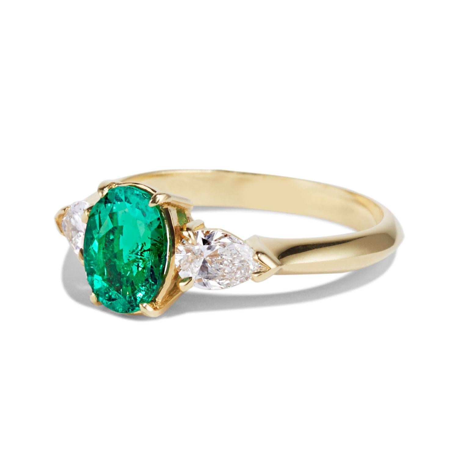 This extraordinarily vibrant Muzo Emerald has been ethically sourced directly from the Muzo mine in Colombia. It is flanked by two pear shaped white diamonds that enhance the natural brightness of the emerald. Set in 18 carat yellow gold, this