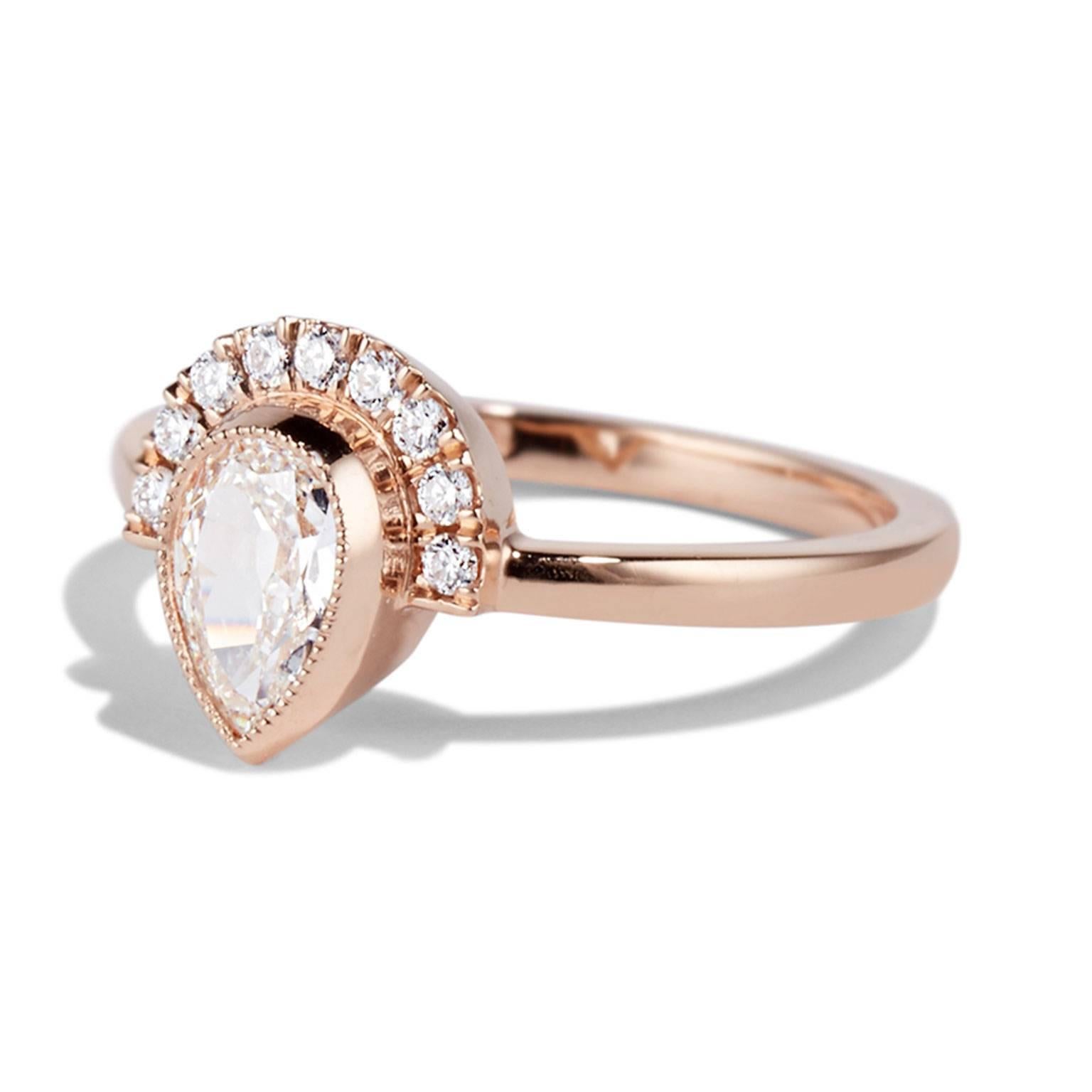 Holly is a contemporary design with antique details. This very special pear shaped diamond is cut in an antique style giving less sparkle and a softer elegant look. This is complemented by the rose gold and milgrain detailing around the halo.