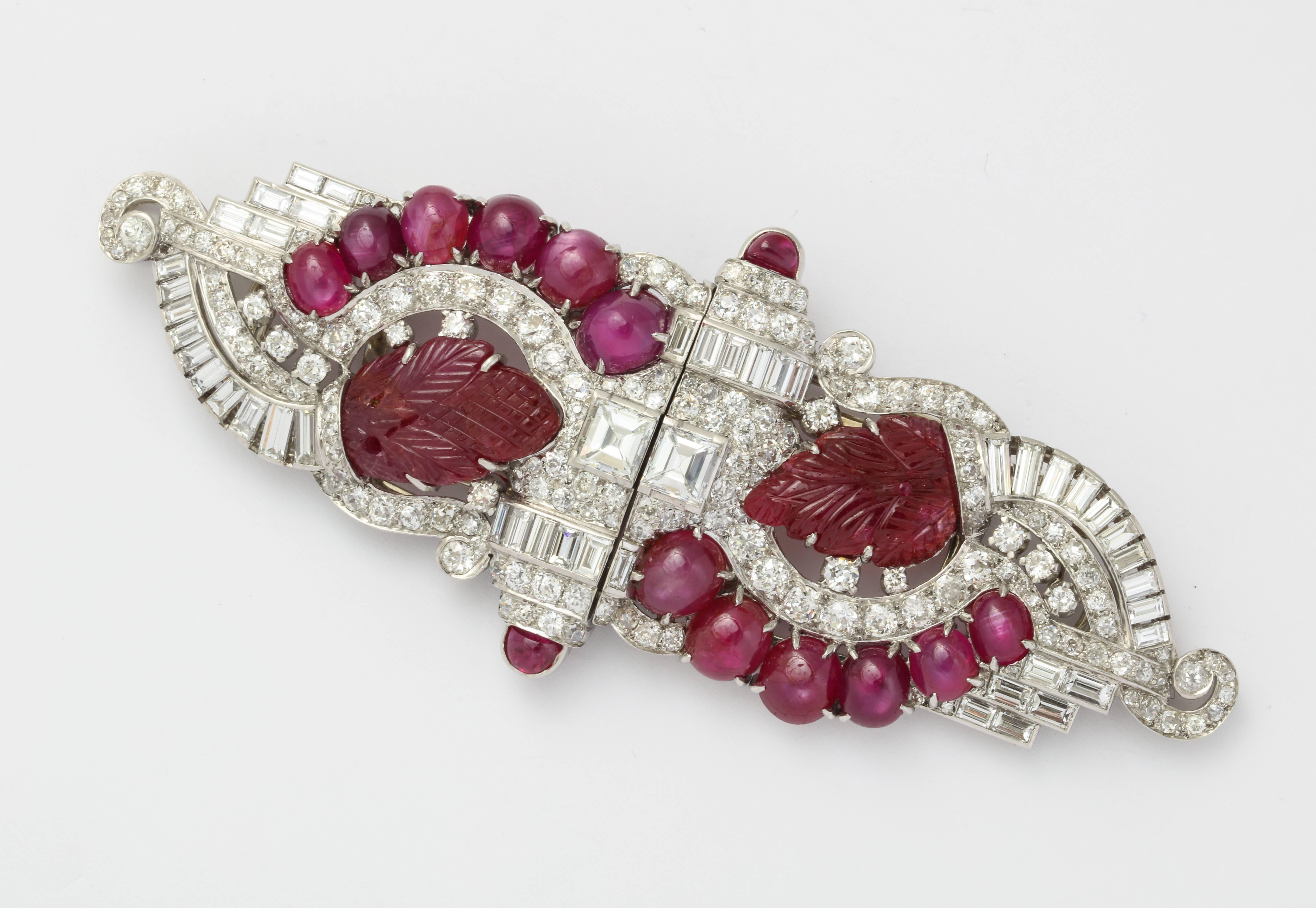 A Very large sized Art Deco ruby, carved ruby double clip that can be worn in three ways:

Together as one brooch, as two separate brooches, and as enhancer on a (later) cultured pearl sautoir length necklace

The double clip measures a very