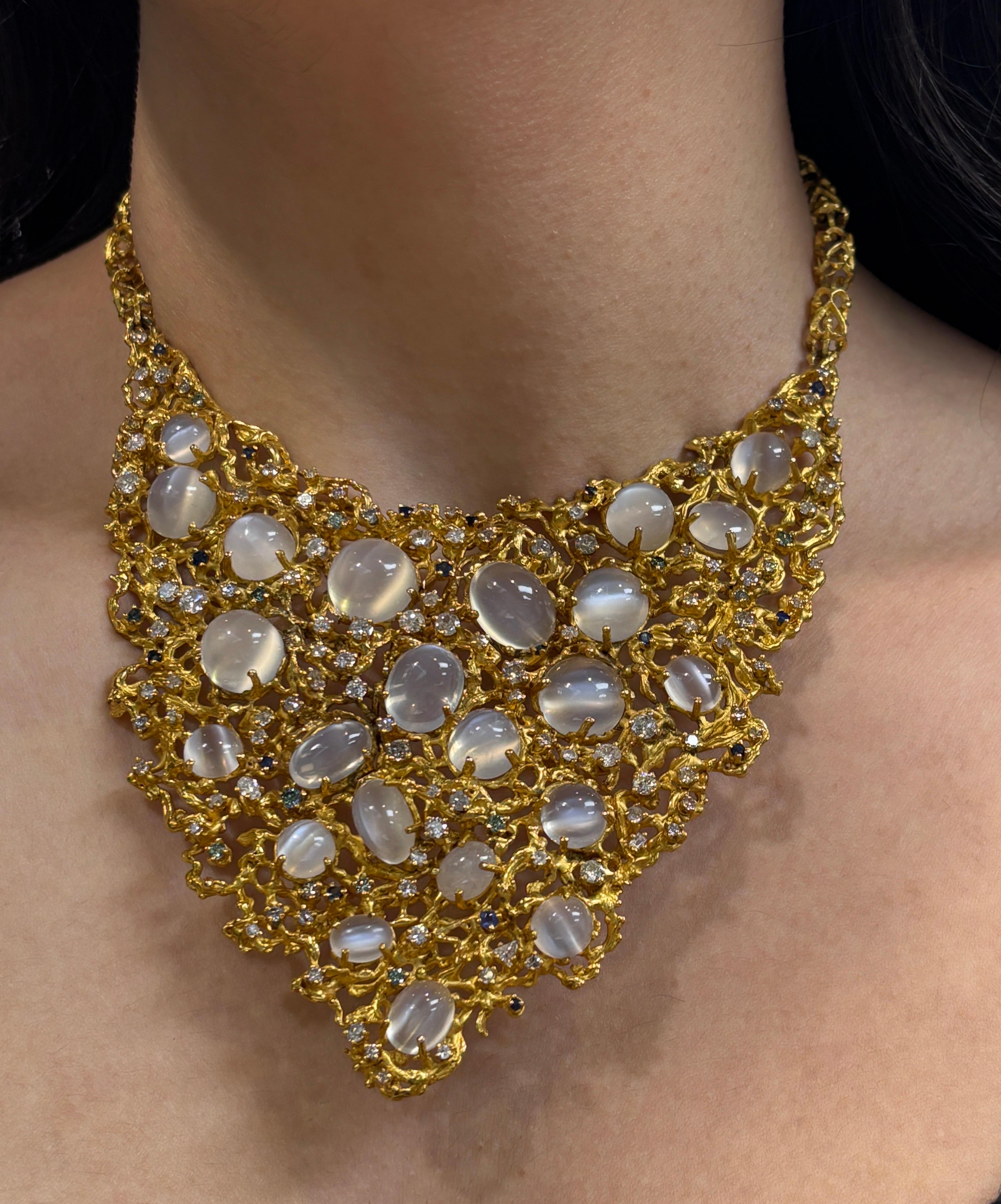 Moonstone Bib Necklace

A large brutalist yellow gold bib necklace set with 22 cabochon moonstones, accented throughout with round green diamonds, sapphires, and mixed-cut white diamonds.

Approximate Combined Weights: 
Moonstone: 151 carats