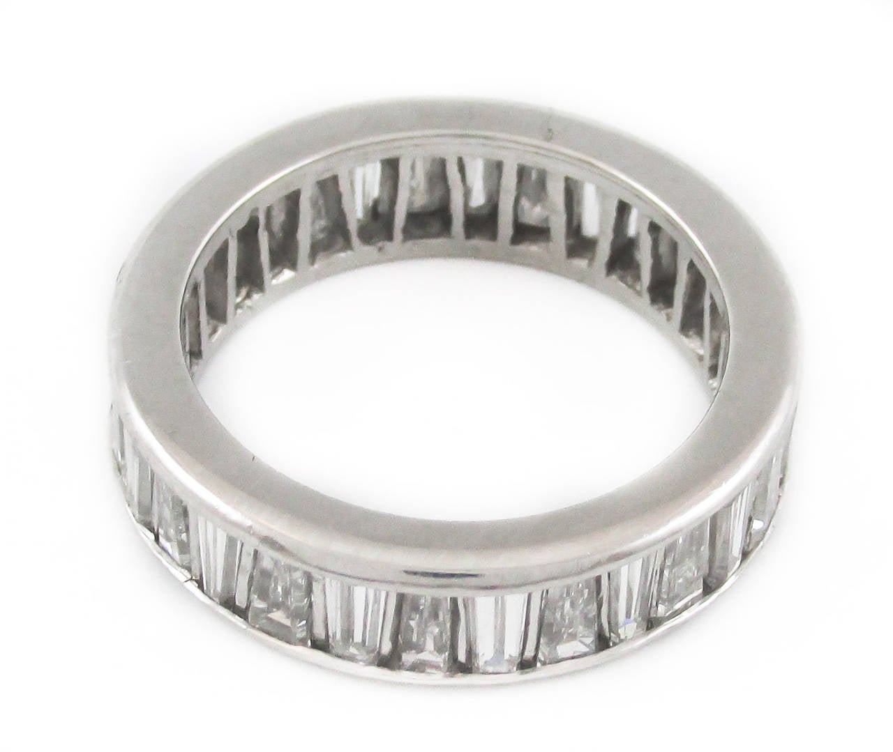 This unusual eternity band is set with 30 revered tapered baguettes diamonds giving the band an interesting play of light. The baguettes are channel set with a thin platinum bar separating each diamond. The average color of the diamonds are G-H and
