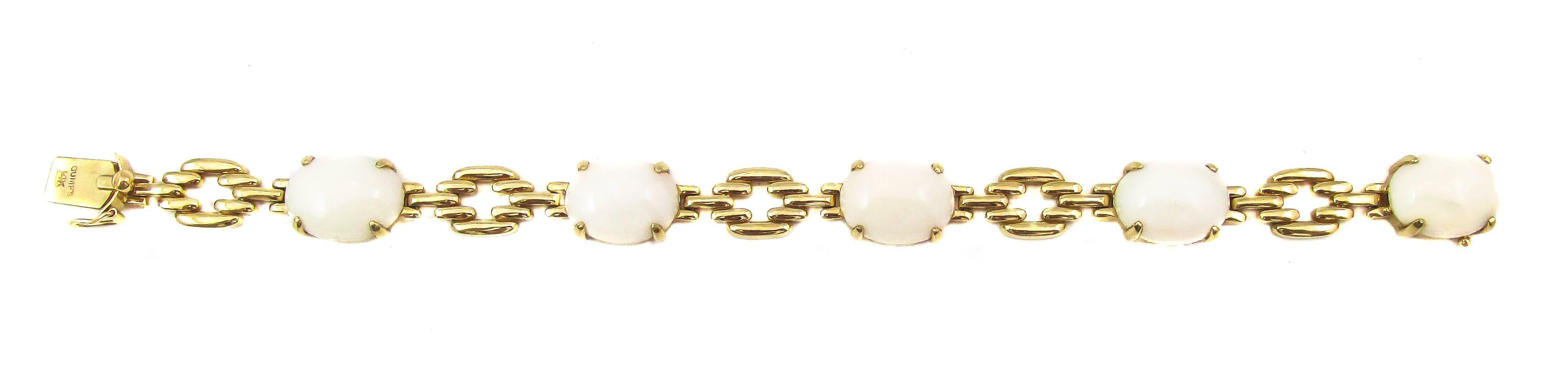 Stylish 1960’s 14 karat yellow gold bracelet set with 5 white coral cabochons. Each gemstone is securely held by 4 eagle claw prongs and connected by brick shape gold links. A fashionable and fun piece of jewelry for everyday wear. The bracelet was