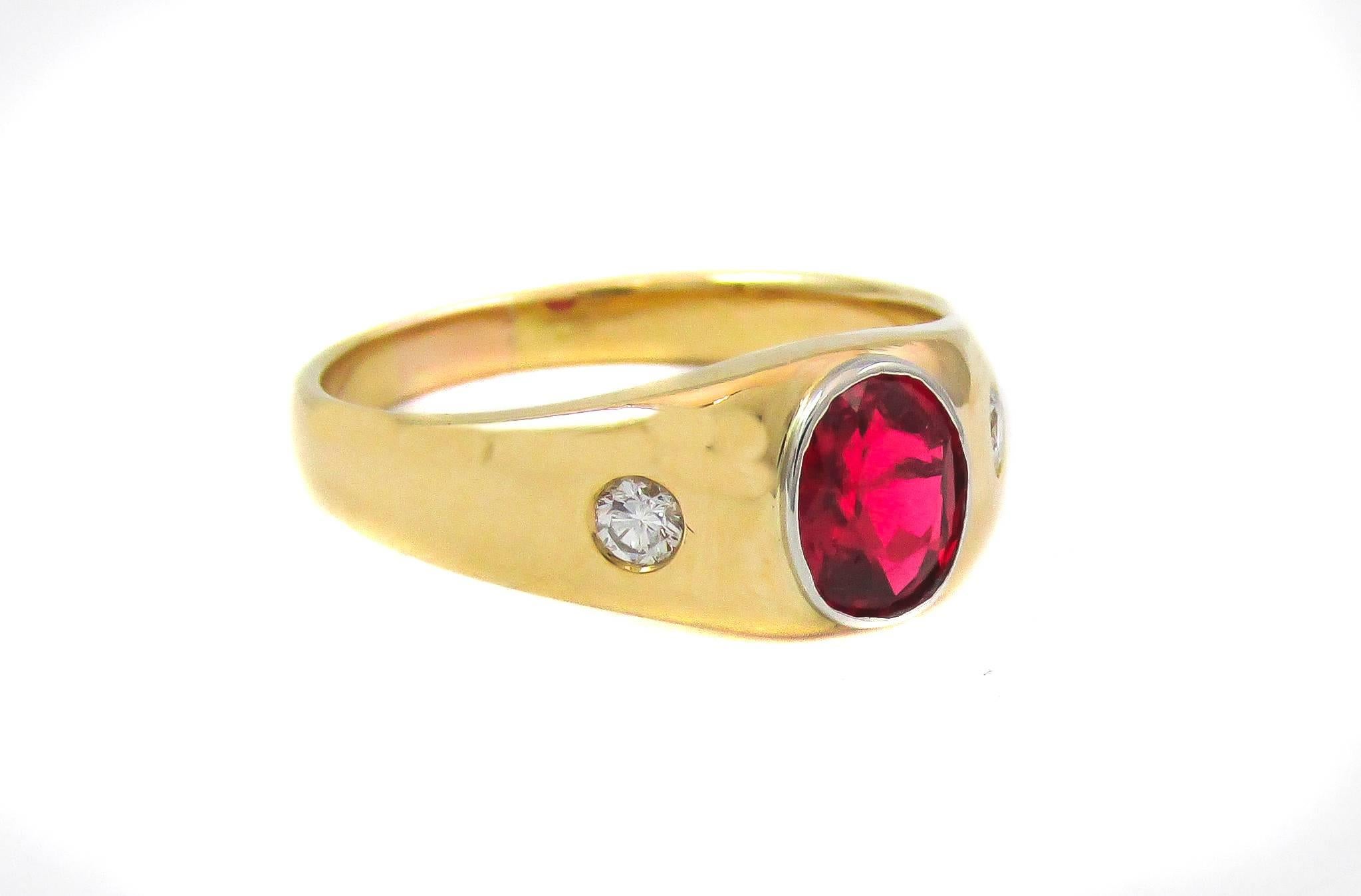 18k yellow gold band centrally set with an oval faceted ruby red spinel weighing approximately 1 carat. The graduating polished gold shank is set with one bright white sparkling round brilliant cut diamond on either side. Red spinels of this color
