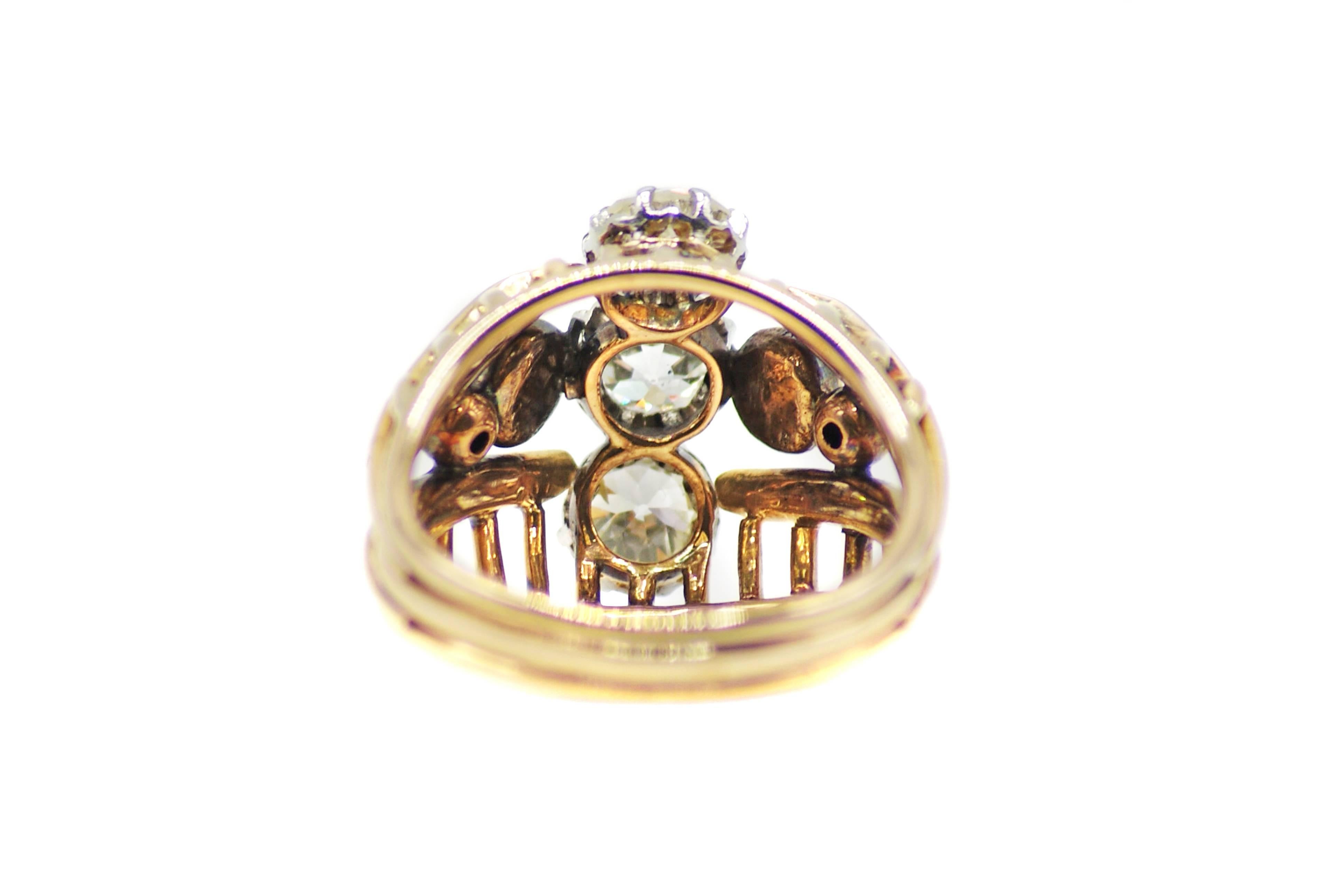 Classic French 18 Karat yellow gold diamond ring from ca. 1940, centrally set with 3 Old European Cut diamonds weighing approximately 1.80 carats in total. The curved shank which is skillfully designed into 3 sections with a grill like pattern on