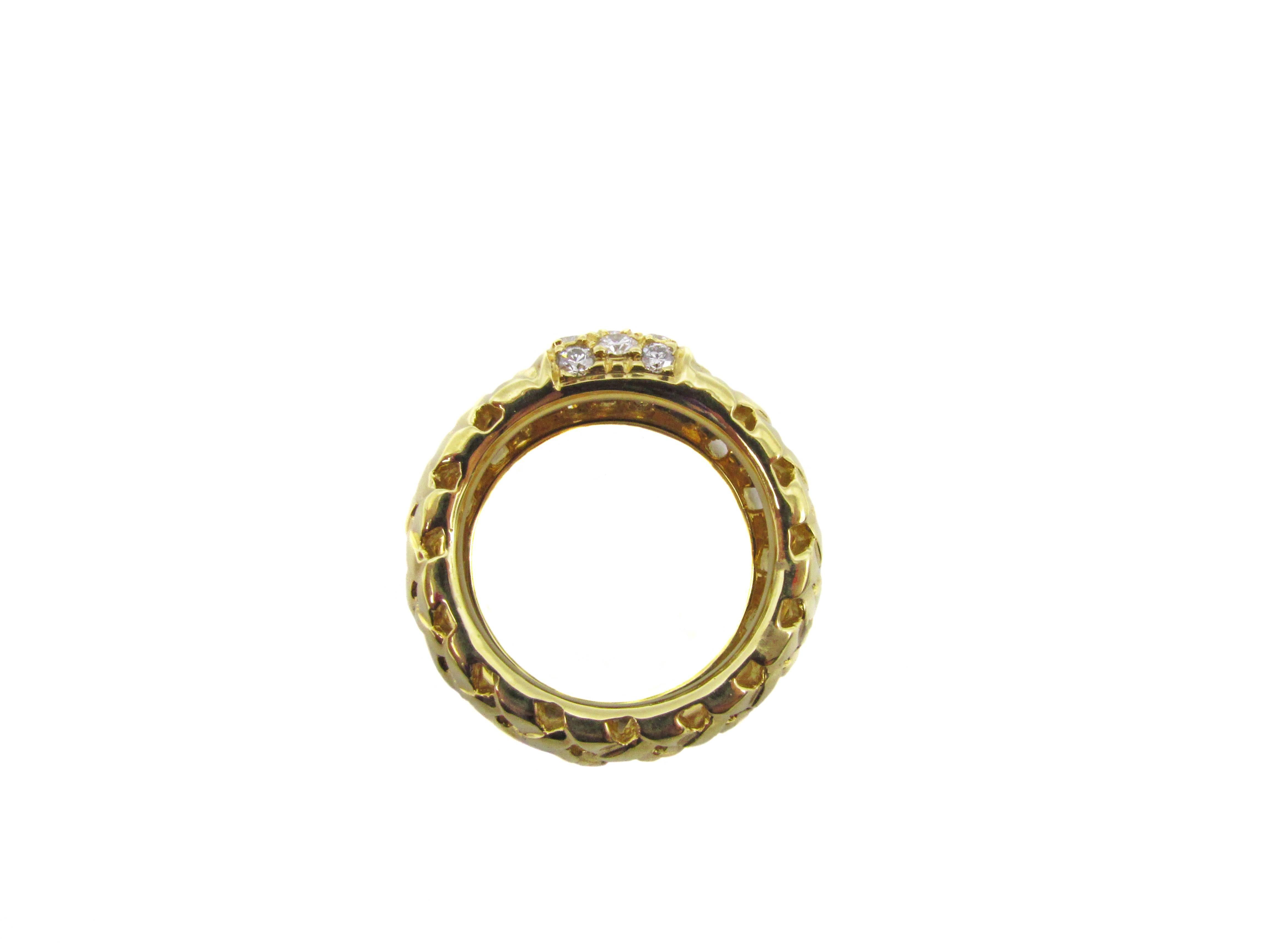 Chic 18 karat yellow gold and diamond band by Tiffany and Co. from the 1995 Vannerie collection. Finely hand crafted polished bands of gold are fashioned in a woven motive giving this band a light and airy look. On the top of the band , a plaque set