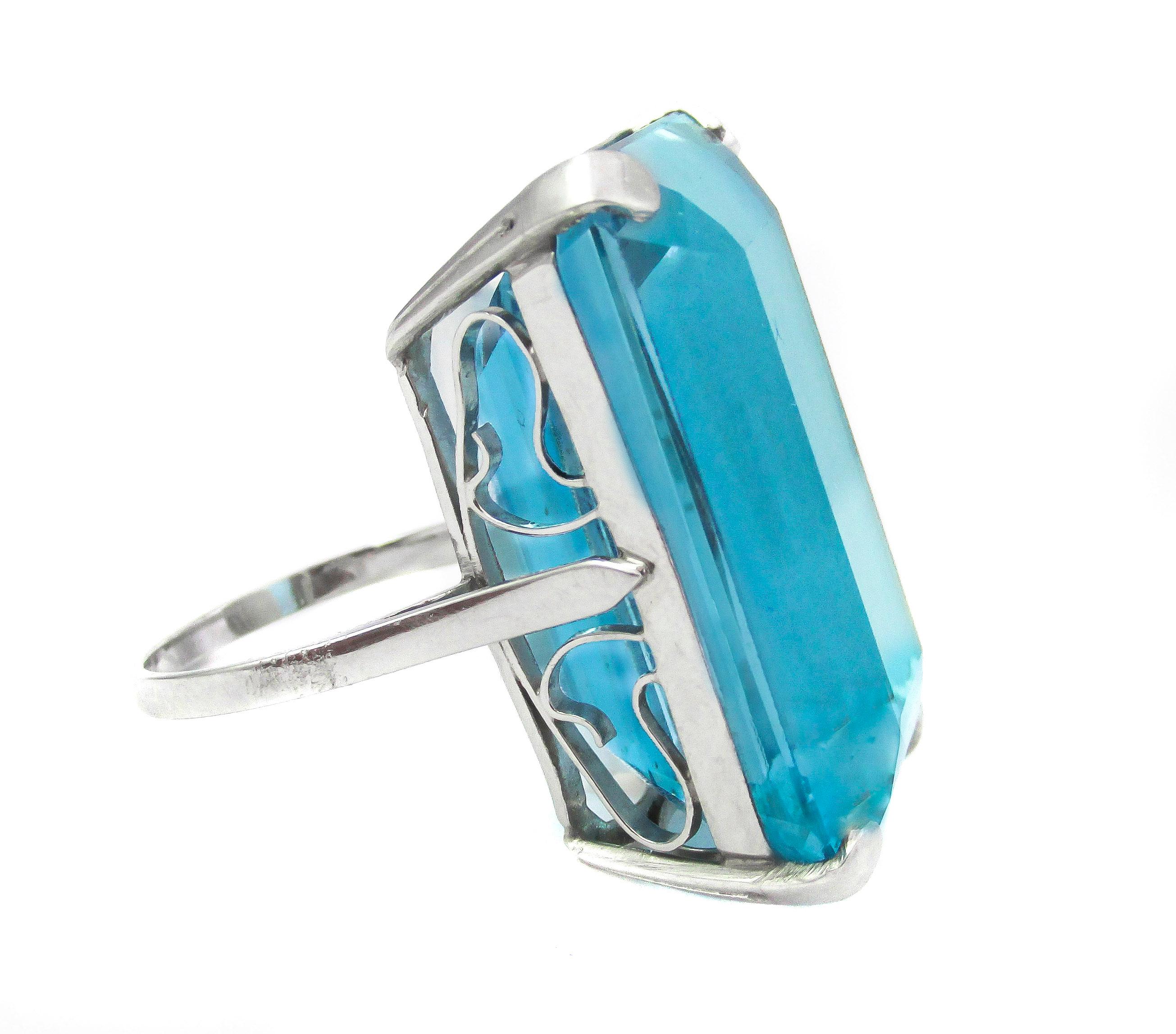 Platinum Retro 1940’s ring set with a stunning 45.50 carat emerald cut Aquamarine. The Aquamarine is perfectly cut, crystal clear and has a rare “Santa Maria” blue color. The amazingly brilliant and lively gemstone is held by 4 prongs on each corner