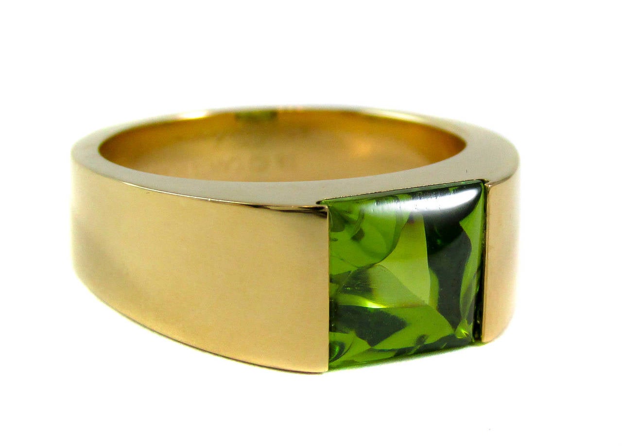 A polished 18 karat yellow gold mounting showcasing a vibrant green square cut peridot creates the fabulous Cartier “Tank” ring. The sumptuous green of the peridot glow in the shiny gold mounting to be seen from miles away. 

- Peridot measuring