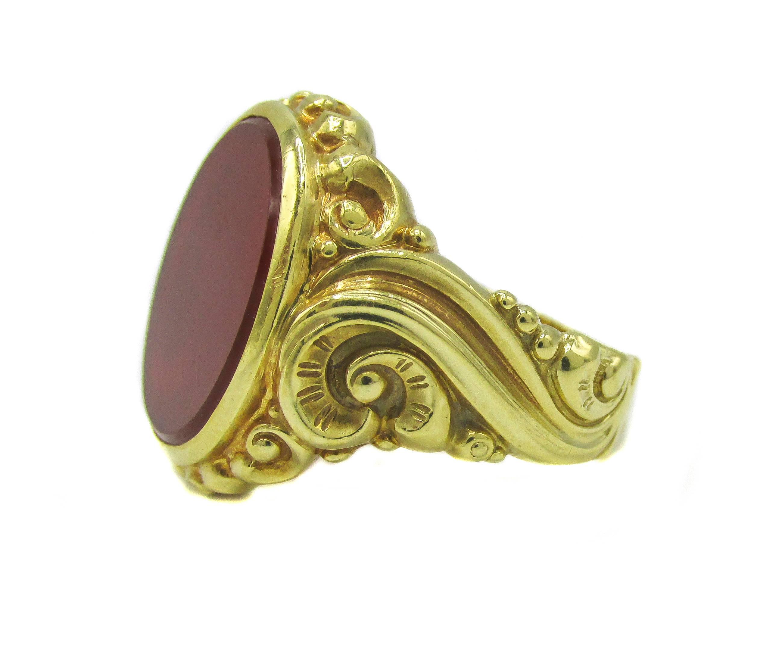 18 karat yellow gold late Victorian seal ring bezel set with a flat smooth oval translucent Carnelian and embellished by fine bead work around the center and elegant scrolls running down the shanks. The inside of the shank is engraved in old script