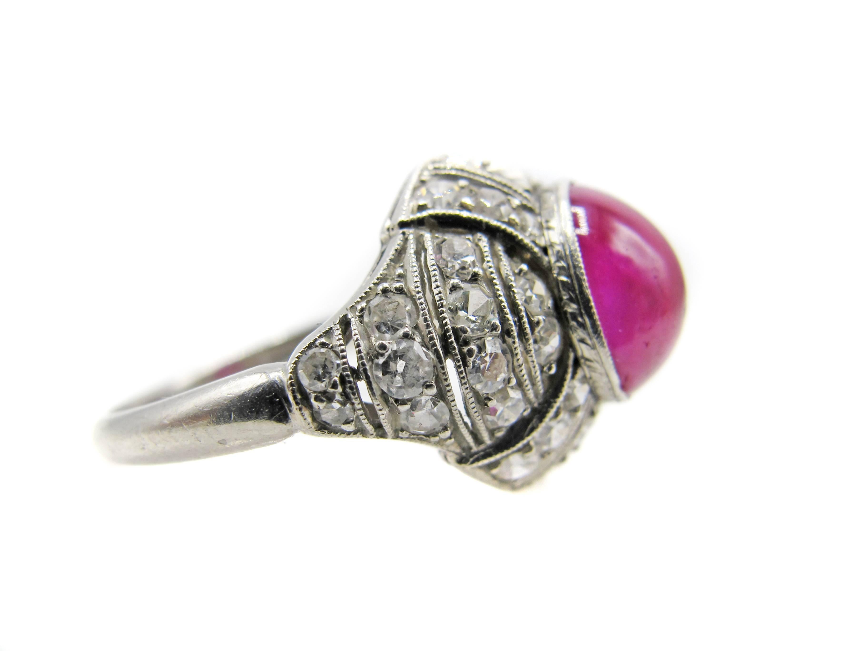 Enchanting French Art-Deco platinum diamond cabochon ruby ring from ca. 1930. The amazing craftsmanship and design of this ring is a true testament to the period it was created. The centrally bezel set Burma cabochon ruby is incredibly clear with