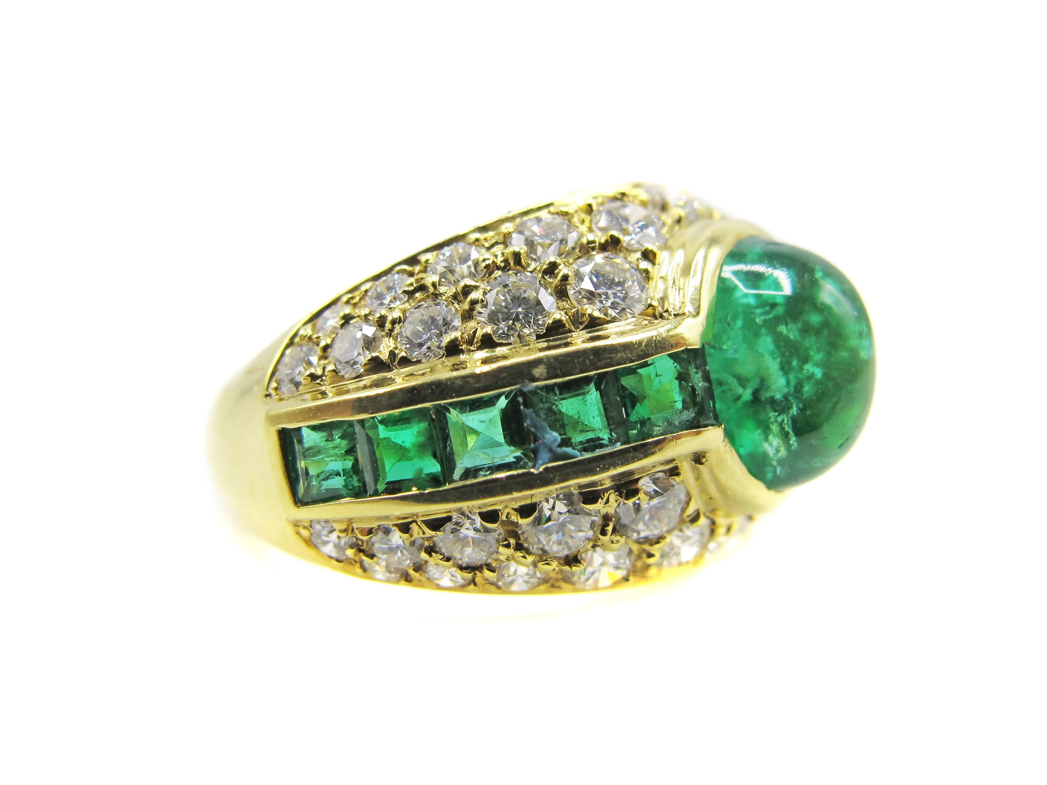 
Chic 1980s 18 Karat yellow gold diamond ring, centrally set with one forest green cabochon emerald weighing approximately 1.85 carats. The cabochon emerald is flanked by 5 beautifully matched square cut emeralds and surrounded by 42 bright white