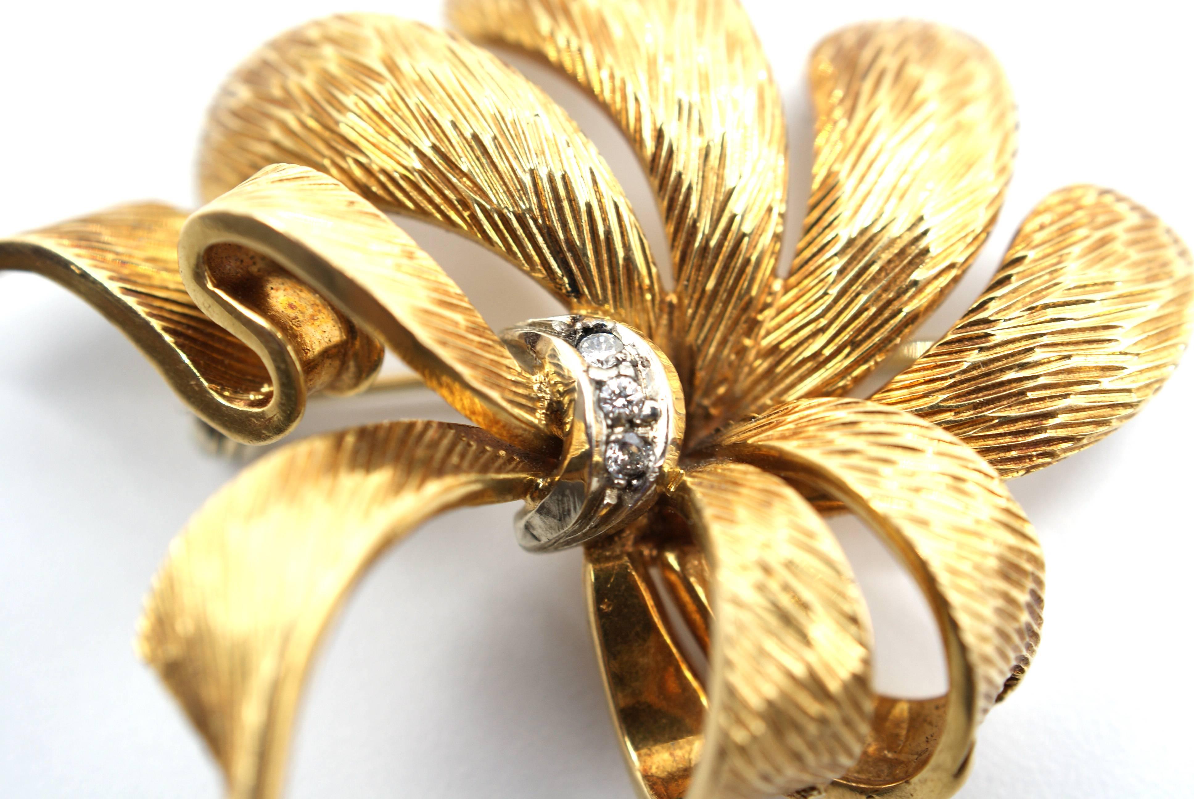 Stylish 1970s brooch handcrafted out 18 karat textured gold, with a floral bow design. The brooch is signed 