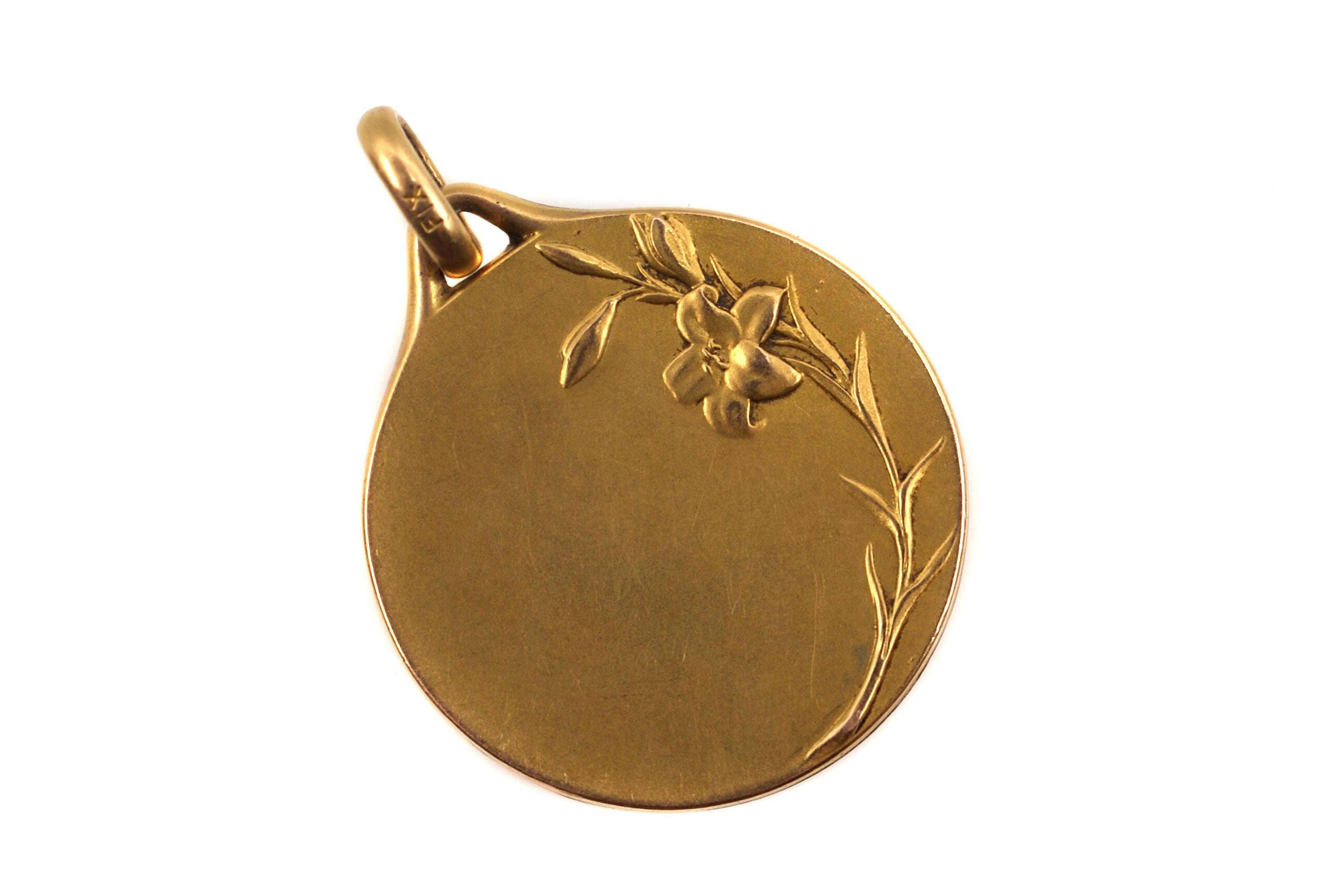 The Art-Nouveau 18 karat yellow gold pendant, from ca. 1880, is a depiction of the Virgin Mary on the front and a floral motif on the back. A true piece of art, immaculately handcrafted, this pendant shows every detail of the face and a finger with