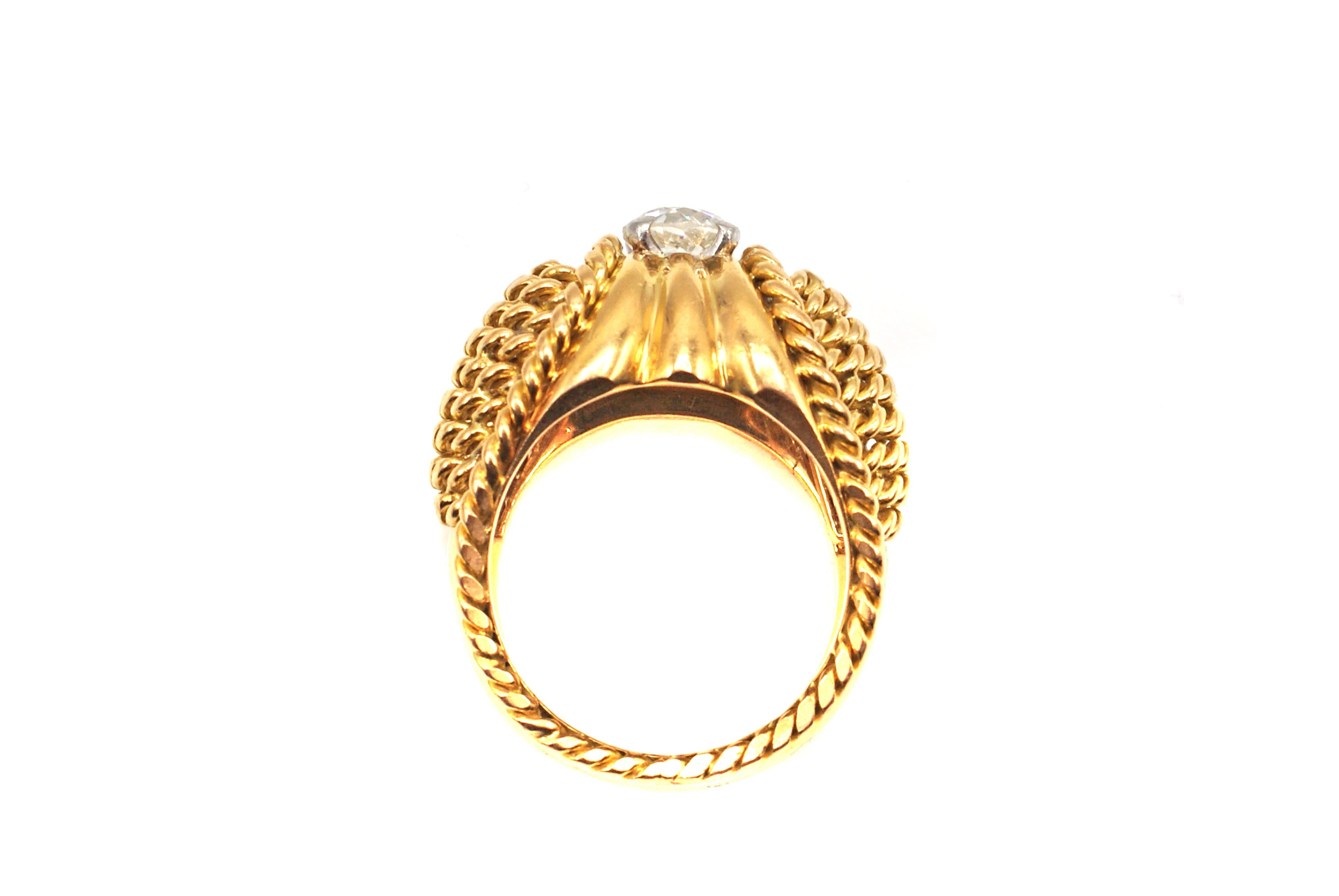 This unique and stylish 18 karat yellow gold Art Deco ring was beautifully designed in ca. 1935. Rows of twisted curb-links curve down each side of the shank flowing into high polished gold with a border of braided gold-work along the sides. The