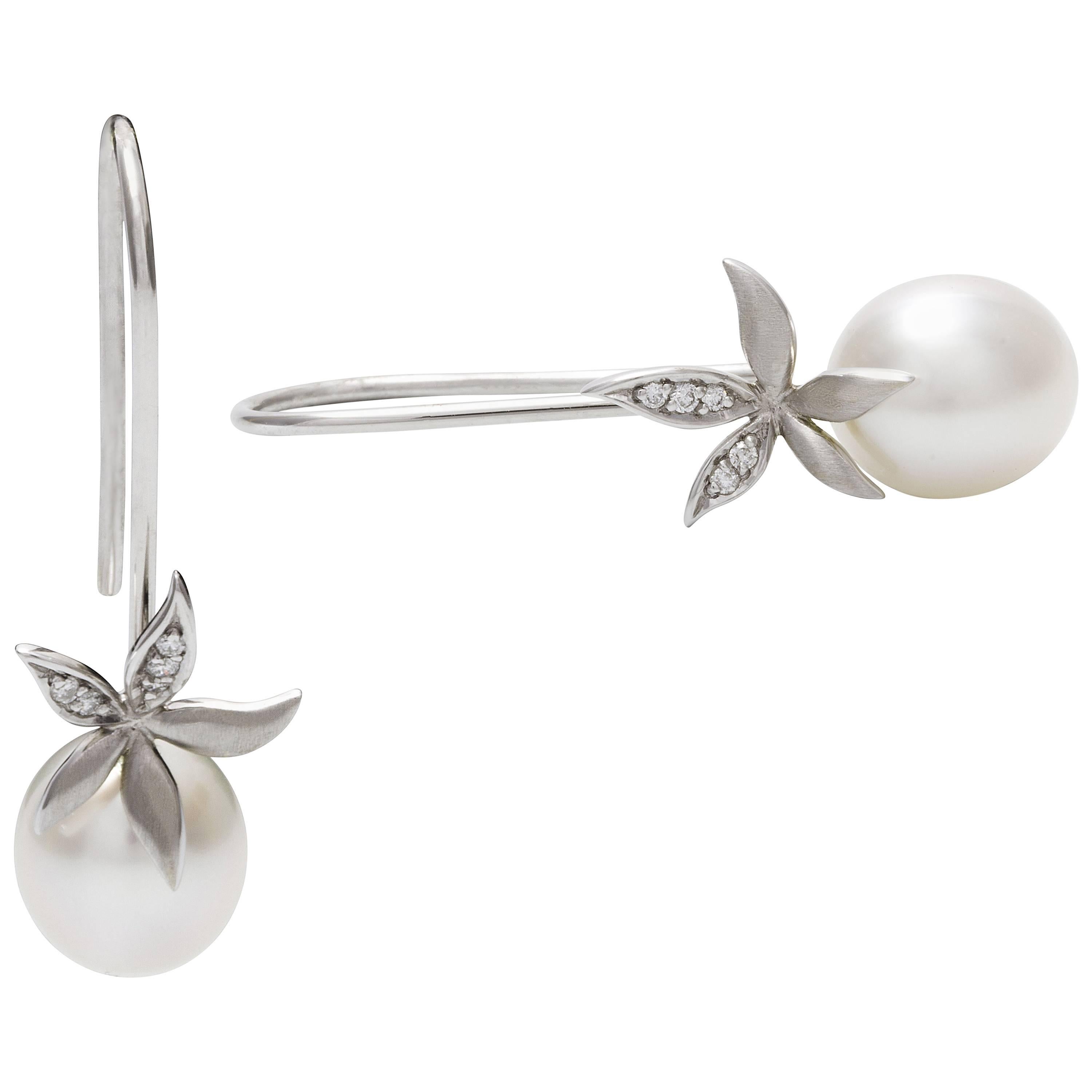 Flowers and pearls...

9 carat white gold shepherd hook flower earrings with 0.06 carat diamonds with beautiful 8-9 mm, drop shaped pearls, grade 1 meaning they have no marks on them, they are of a fine smooth surface with very high luster and white
