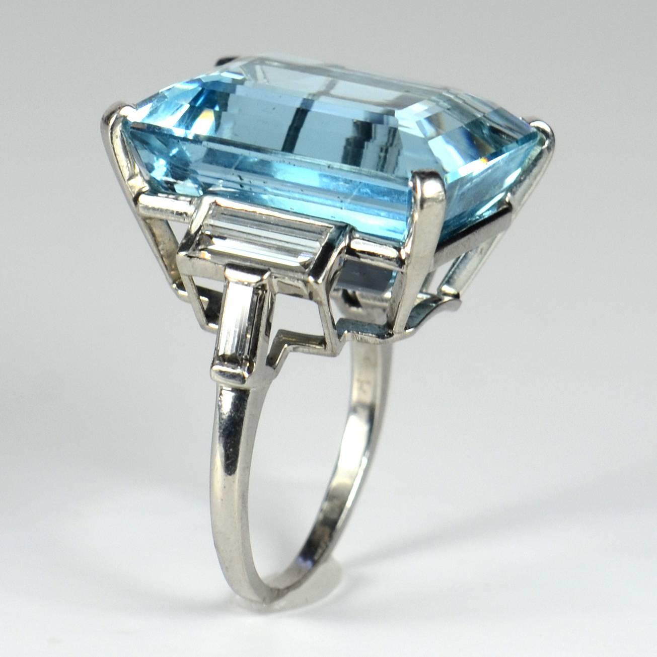 A fine aquamarine, diamond and platinum cocktail ring by Trabert & Hoeffer Mauboussin from the Retro period set with a rectangular step-cut aquamarine.  The geometric shoulders are each set with three elegant baguette-cut diamonds.  The