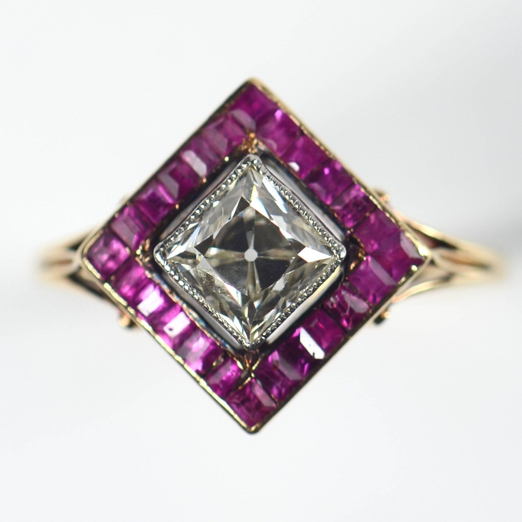 An unusual and very elegant Edwardian ruby and diamond cluster ring, set with a 1.20 carat old mine cut diamond, surrounded by calibre cut rubies.  The gold shank is bifurcated and scrolls up to meet the pierced gallery of the head of the ring.

The