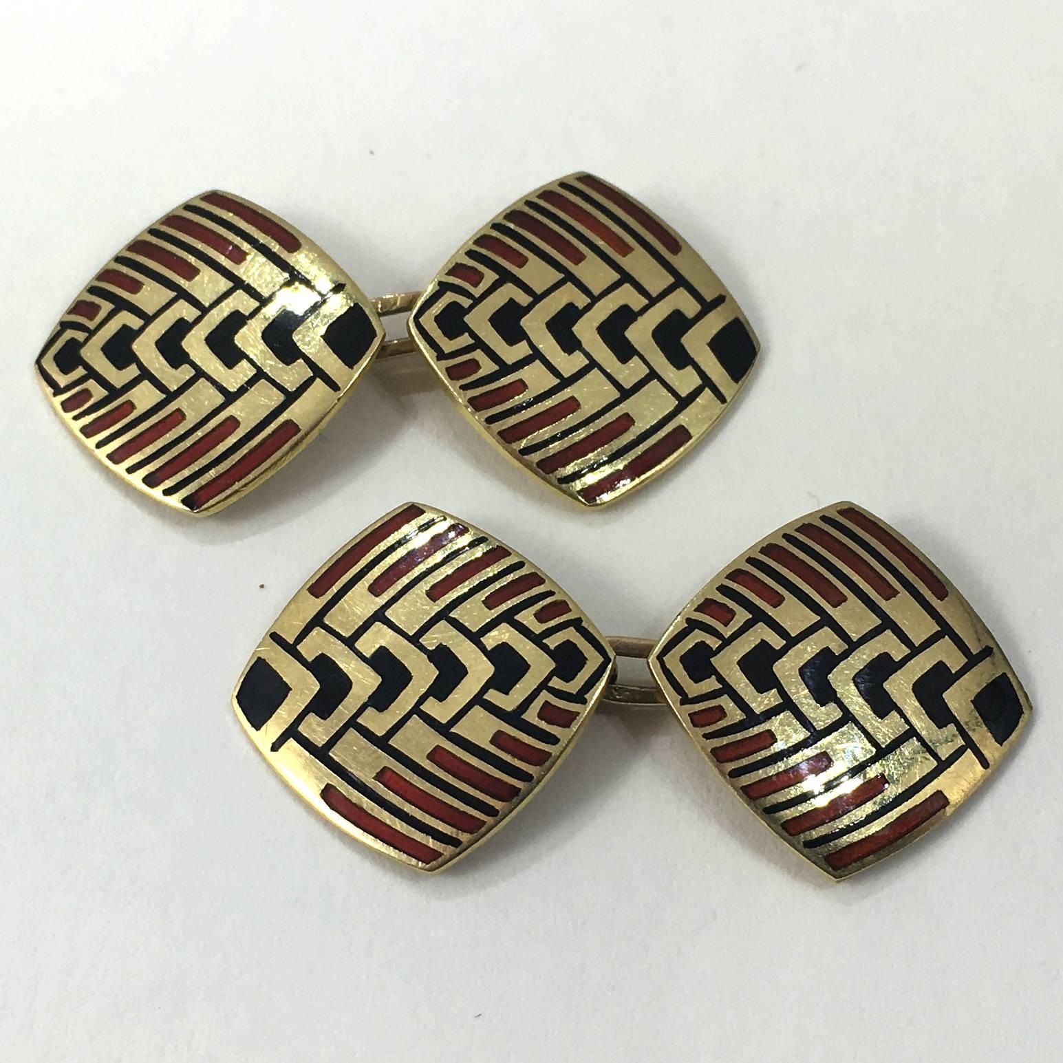 A pair of Art Deco double cufflinks with a geometric design of stylised feathers depicted by a black enamel chevron pattern with extended lines highlighted by red enamel bars on a gold base.

The red and black colour combination is typical of the