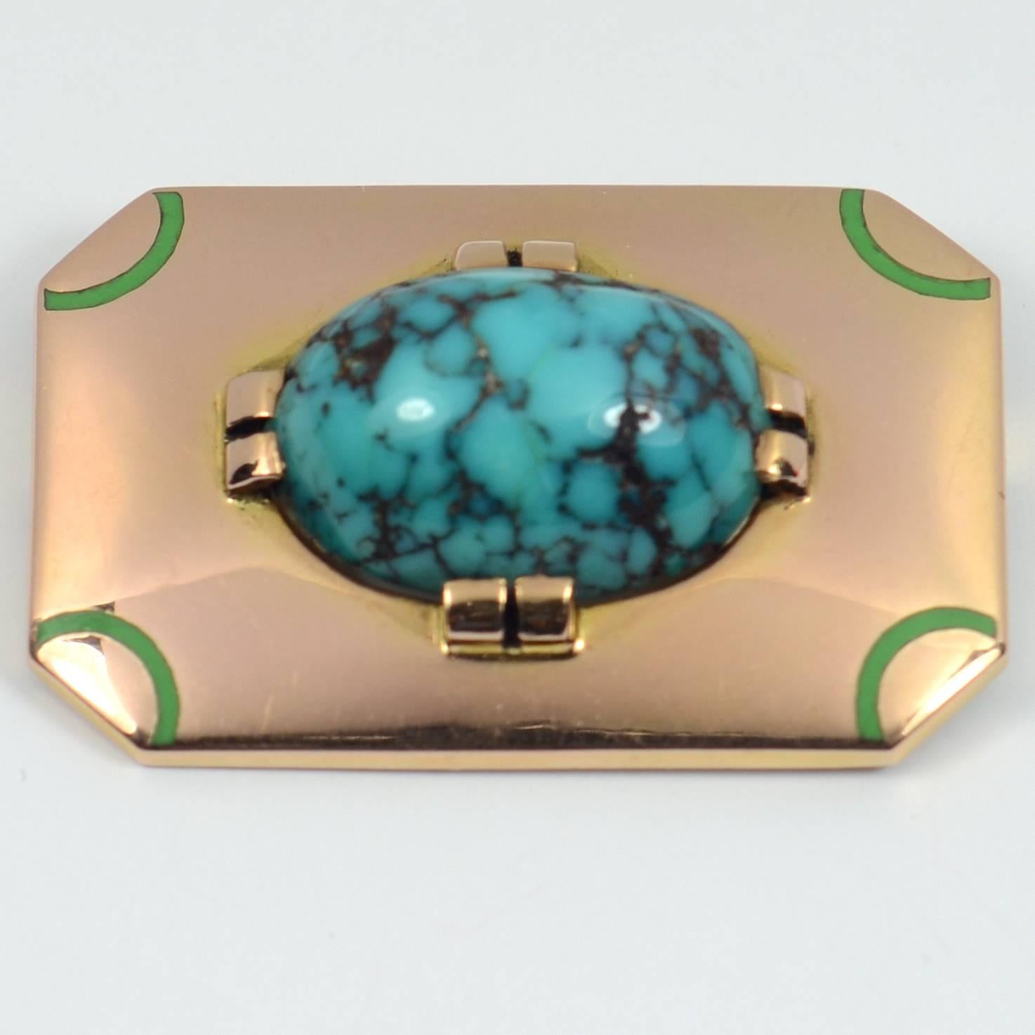 A very smart Art Deco brooch designed as a rectangular plaque of gold with truncated corners giving an octagonal outline, highlighted to the corners with arcs of green enamel and set with a large cabochon of turquoise.

The turquoise cabochon is