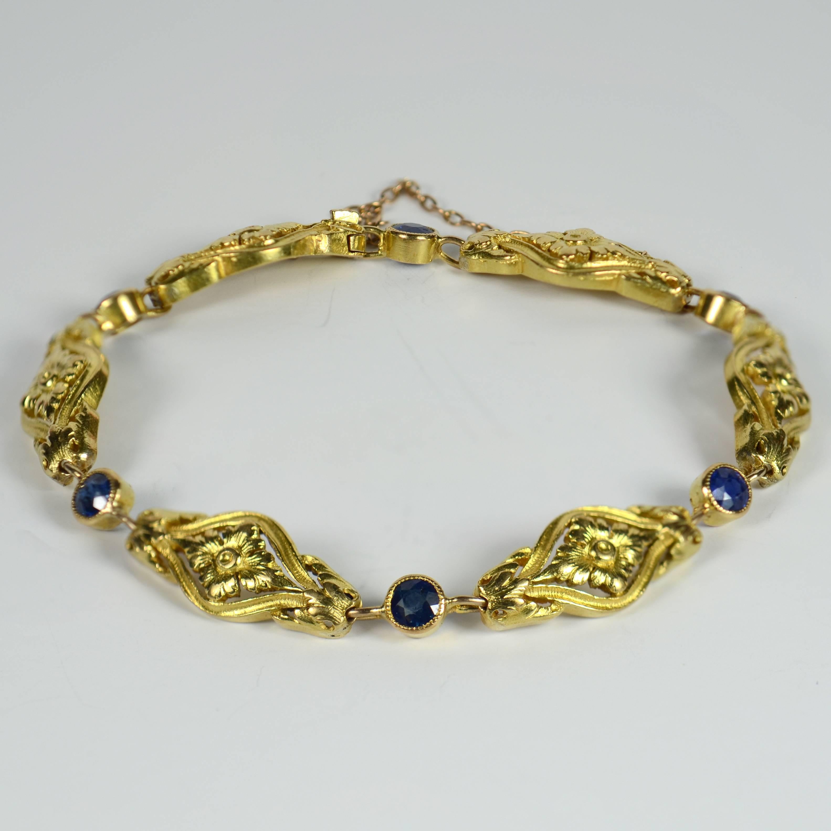 A pretty French 18 carat gold link bracelet in the Art Nouveau style set with 6 blue sapphires.  Each of the six gold links of this bracelet has a flower and leaf motif, interspaced with a blue sapphire in a millegrain setting.  

Each sapphire is