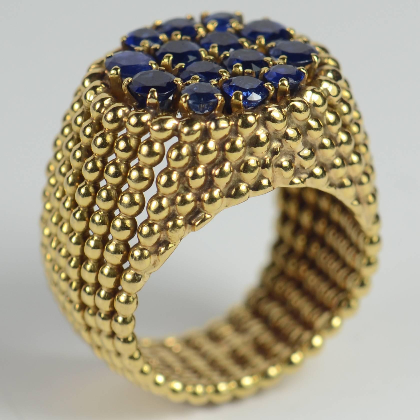 A 18 carat yellow gold ring of French manufacture designed as ridges of gold balls rising around the shank to meet a flat plaque set with 16 natural, unheated round-cut sapphires weighing approximately 2.30 carats in total.

The ring is stamped with