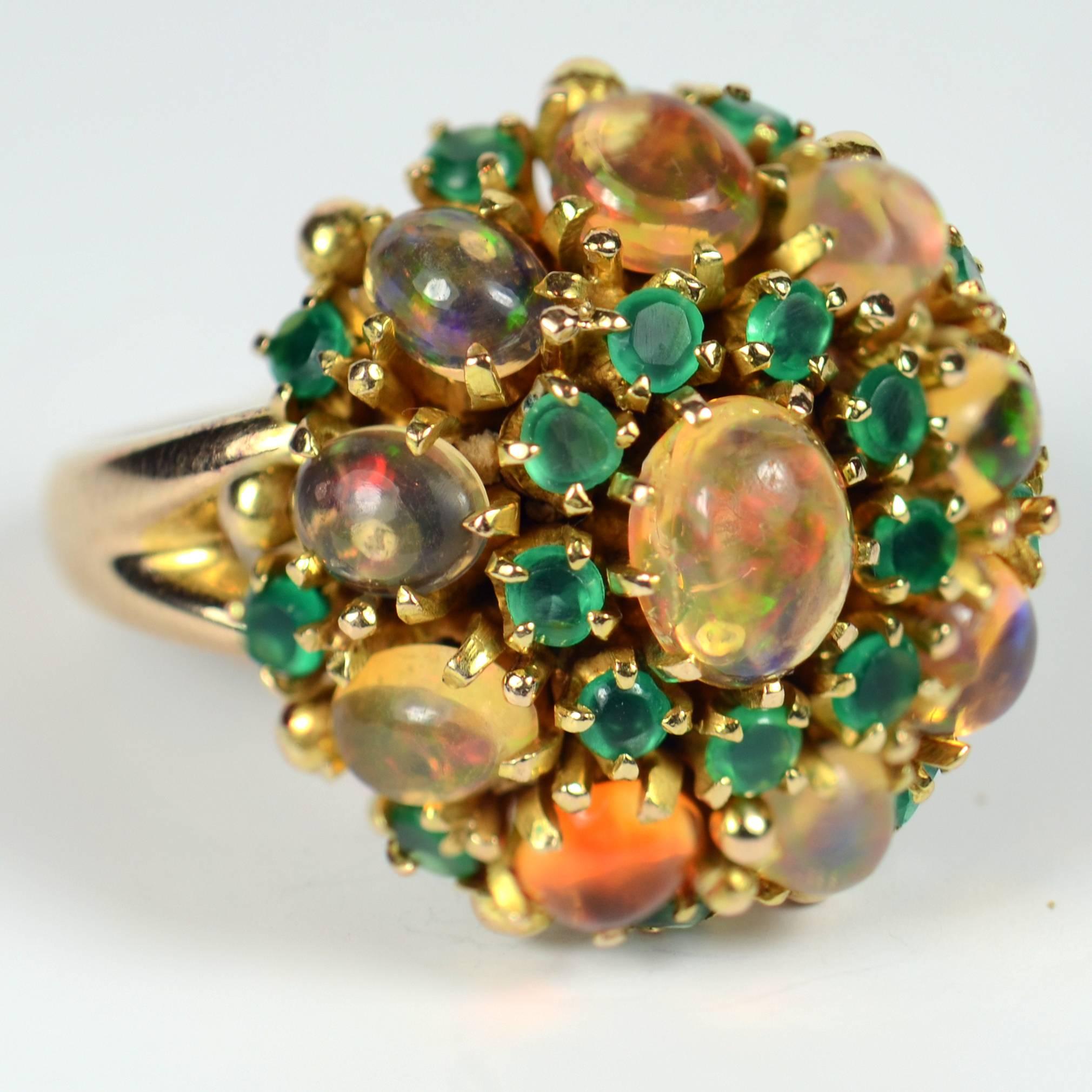 An attractive bombé cluster ring set with oval fire opals with good play of colour interspaced with dyed green agates.

The ring is stamped 18 for 18 carat gold and has been fitted with a pair of sizing balls to bring it down to a size 6.  By