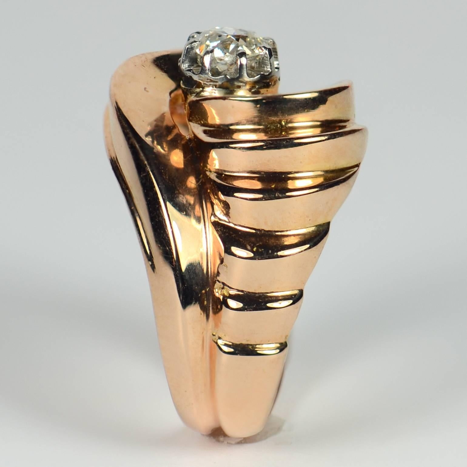 This elegant French 'Tourbillon' Retro ring has a great sculptural feel to it, with asymmetric stepped swirls on each side of the rose gold shank curving to cradle an old cushion-cut diamond weighing approximately 0.35 carats.  

Diamond weight