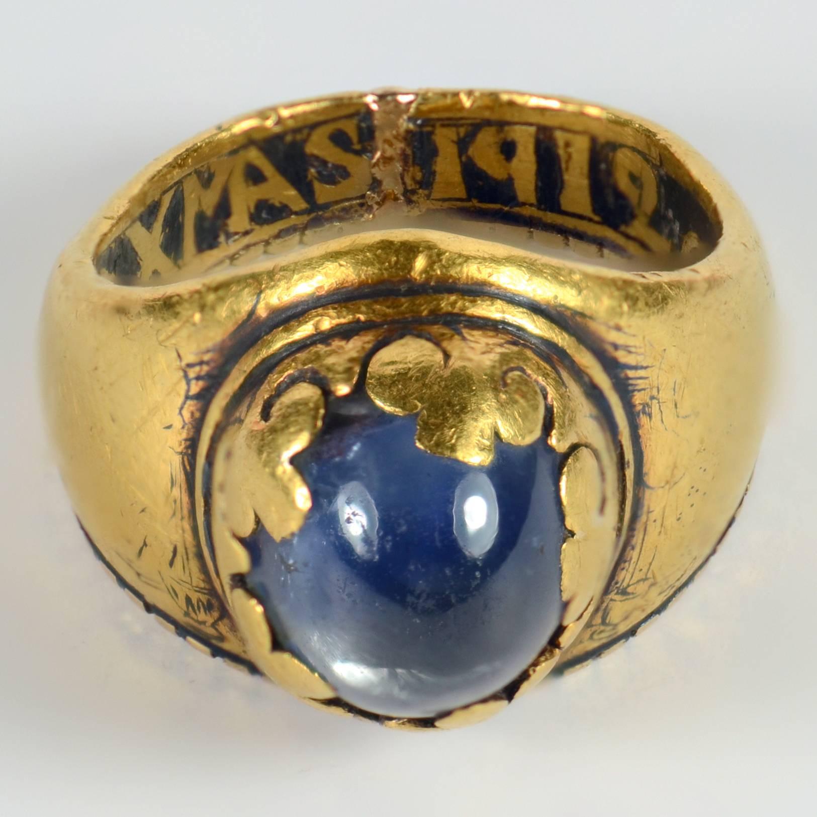 A very unusual antique ring set with a cabochon blue sapphire collet set to cut-out fleur-de-lis. The tapering hoop has a mitre-shaped bezel which may indicate an Episcopal origin. The ring was originally detailed in niello, but this has sadly been