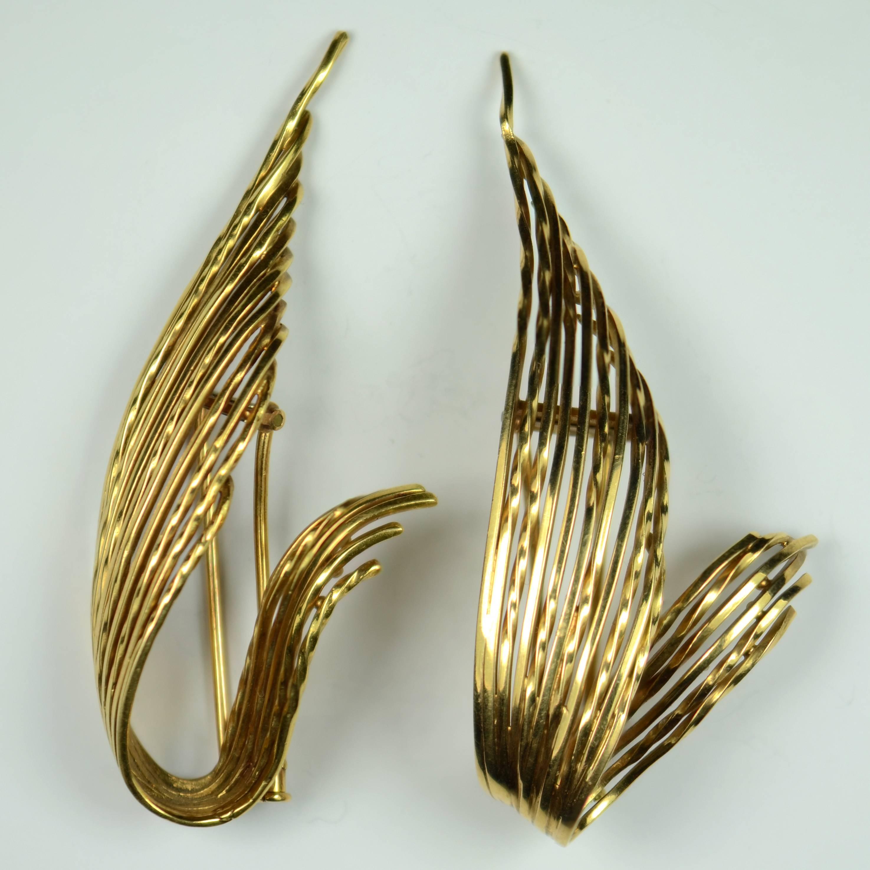 A pair of 18 carat gold clip brooches by Pierre Sterlé designed as a pair of abstracted feathers.  The rounded form of these brooches has a bold 3-dimensional feel with twisted wirework giving textural interest.

Both clips are stamped with the