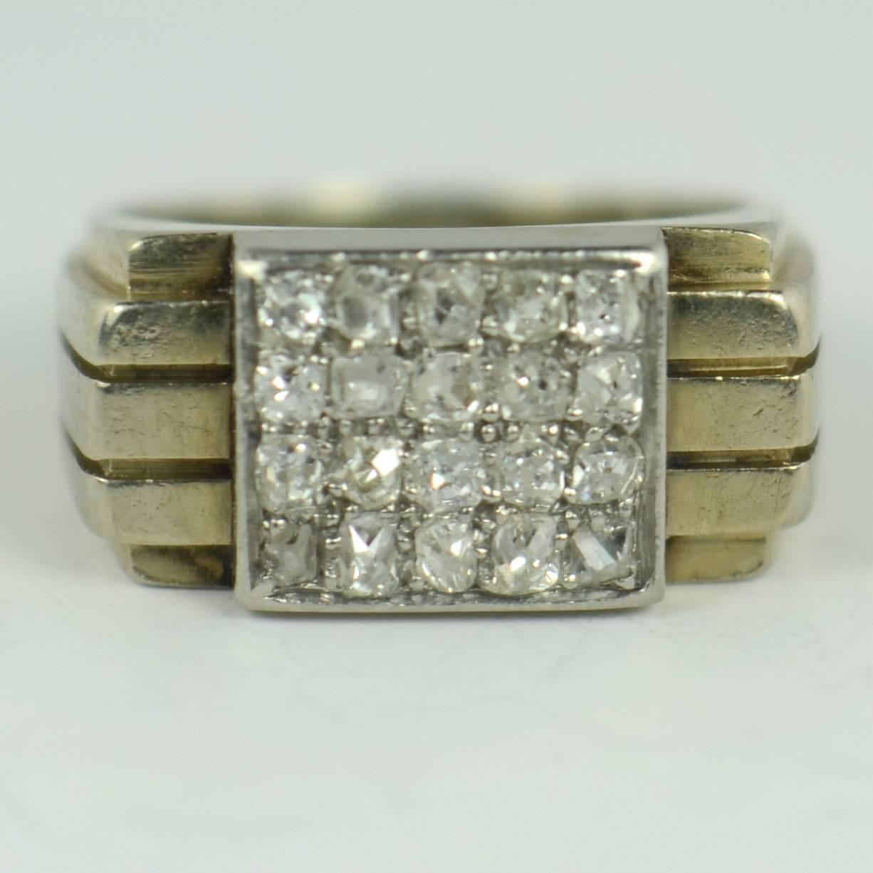 A French ring circa 1930 with an 18 carat white gold tapering shank with geometric form and three raised ridges to a panel of platinum set with twenty old single cut diamonds with a total approximate weight of 0.50 carats.  

The ring is marked with