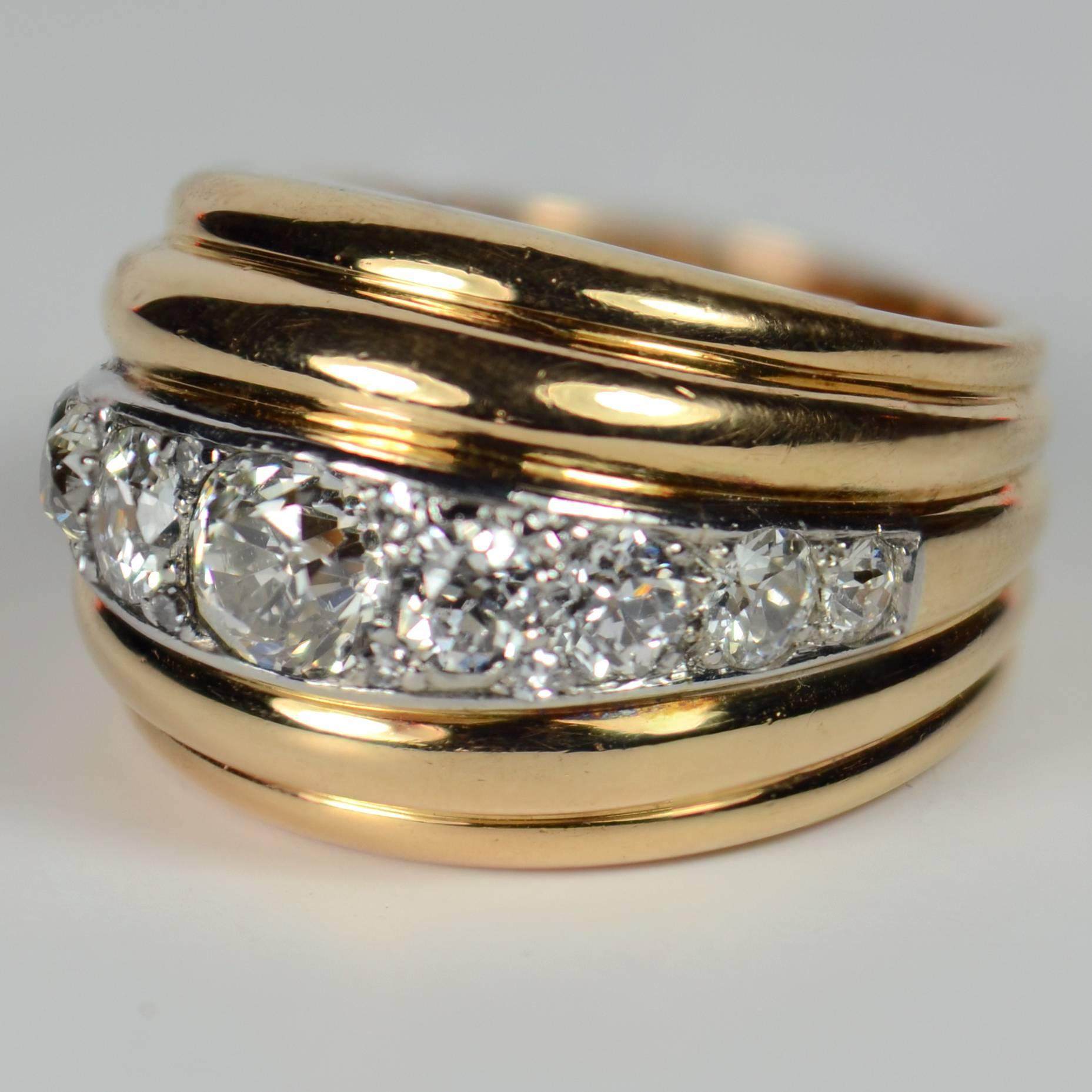 A dramatic gold and diamond dome ring in the style of Belperron, designed as five curving ridges, the central ridge set with diamonds in platinum.

The 9 main diamonds are old transitional cut stones, which are interspersed with 8 smaller single-cut