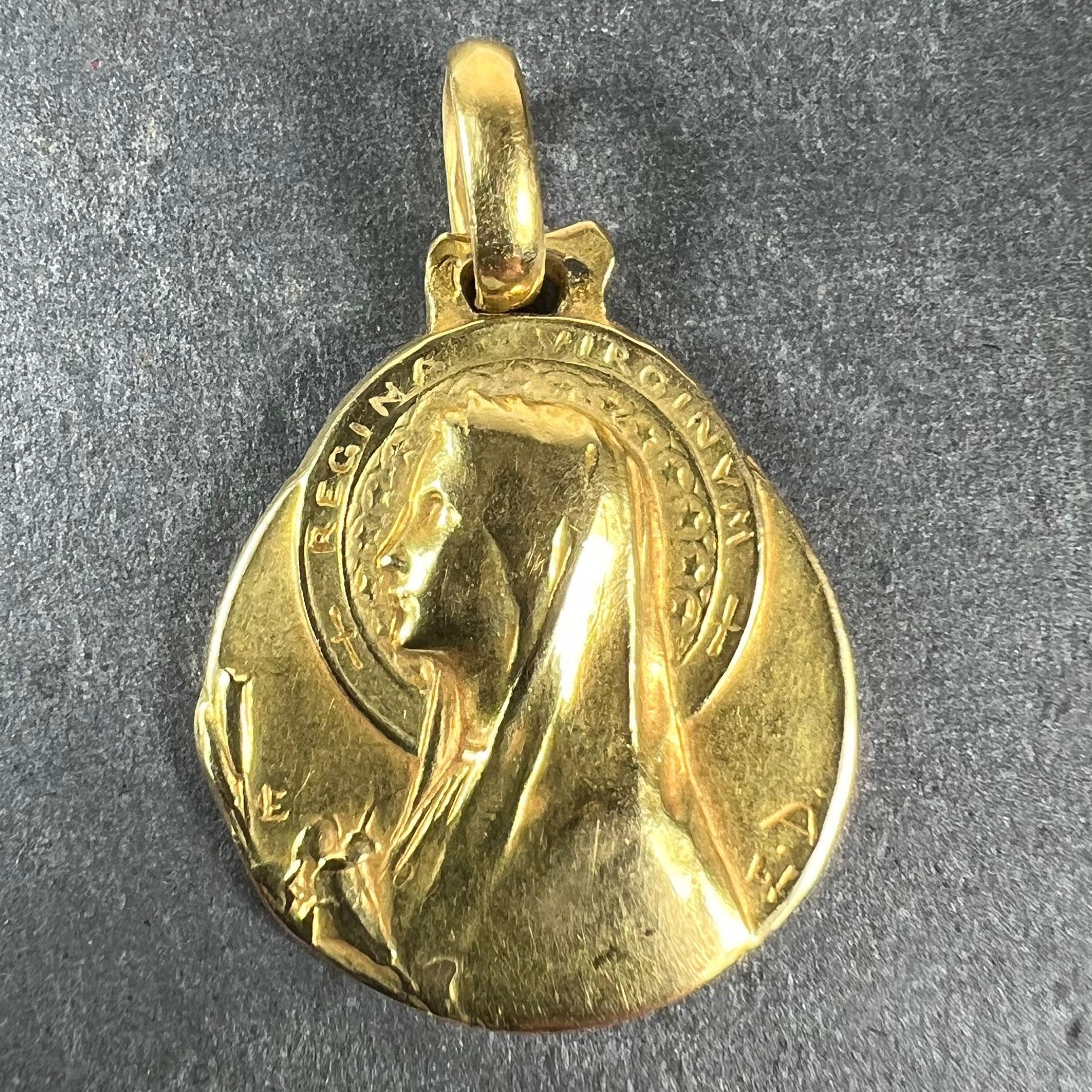 An 18 karat (18K) yellow gold pendant designed as a medal depicting the Virgin Mary holding a lily with the inscription ‘Regina Virginum’ surrounding her halo. Signed E.D for Emile Dropsy. The reverse depicts a sheaf of roses and is engraved