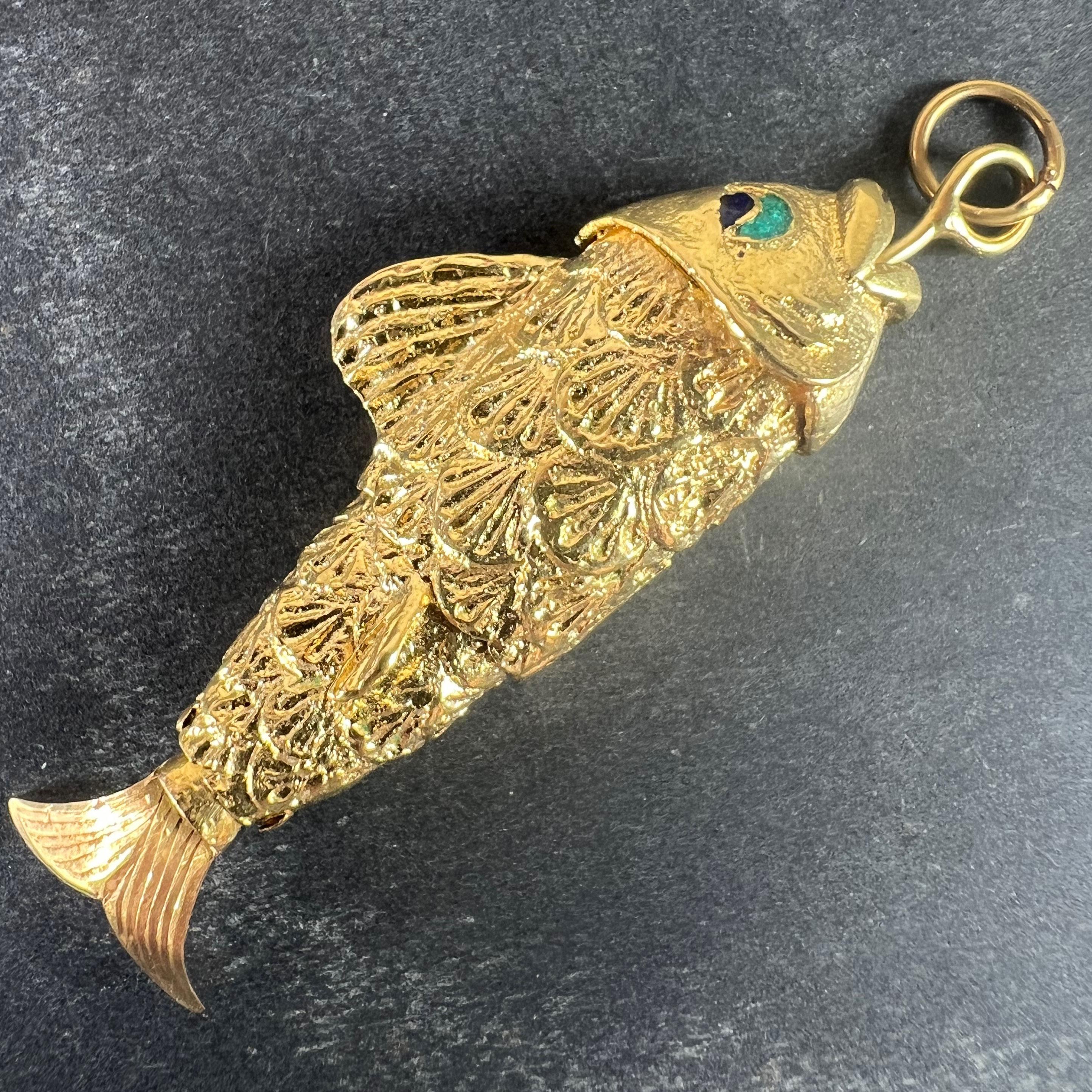 Colgante de oro amarillo de 18 quilates (18K) en forma de pez con cola flexible articulada y ojos esmaltados. Sin marcar pero probada para oro de 18 quilates.

Dimensiones: 5,9 x 1,9 x 1,05 cm (sin incluir la anilla de salto)
Peso: 14.78 gramos 
