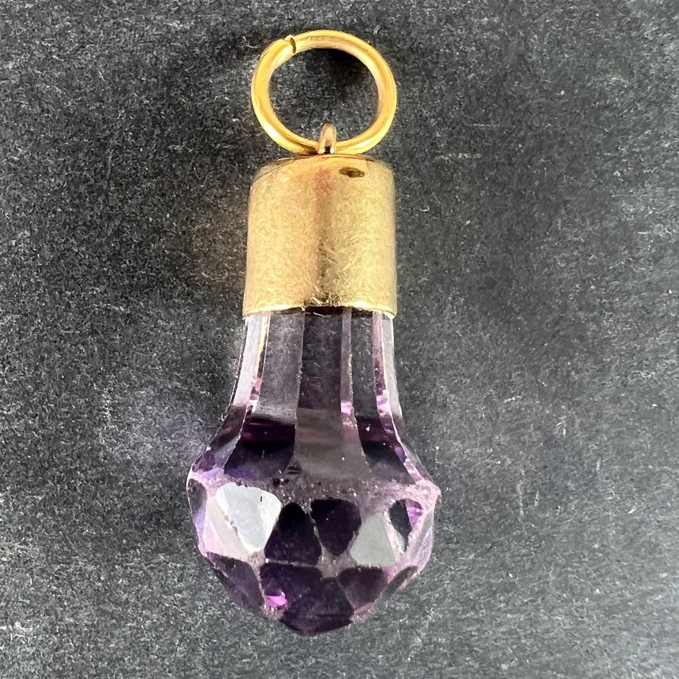 Un ciondolo in oro giallo 18 carati (18K) con un ciondolo a forma di ametista sfaccettata. Non marcato ma testato come oro a 18 carati.

Dimensioni: 2,4 x 1,15 x 1,15 cm (escluso l'anello di sospensione)
Peso: 3,54 grammi 
