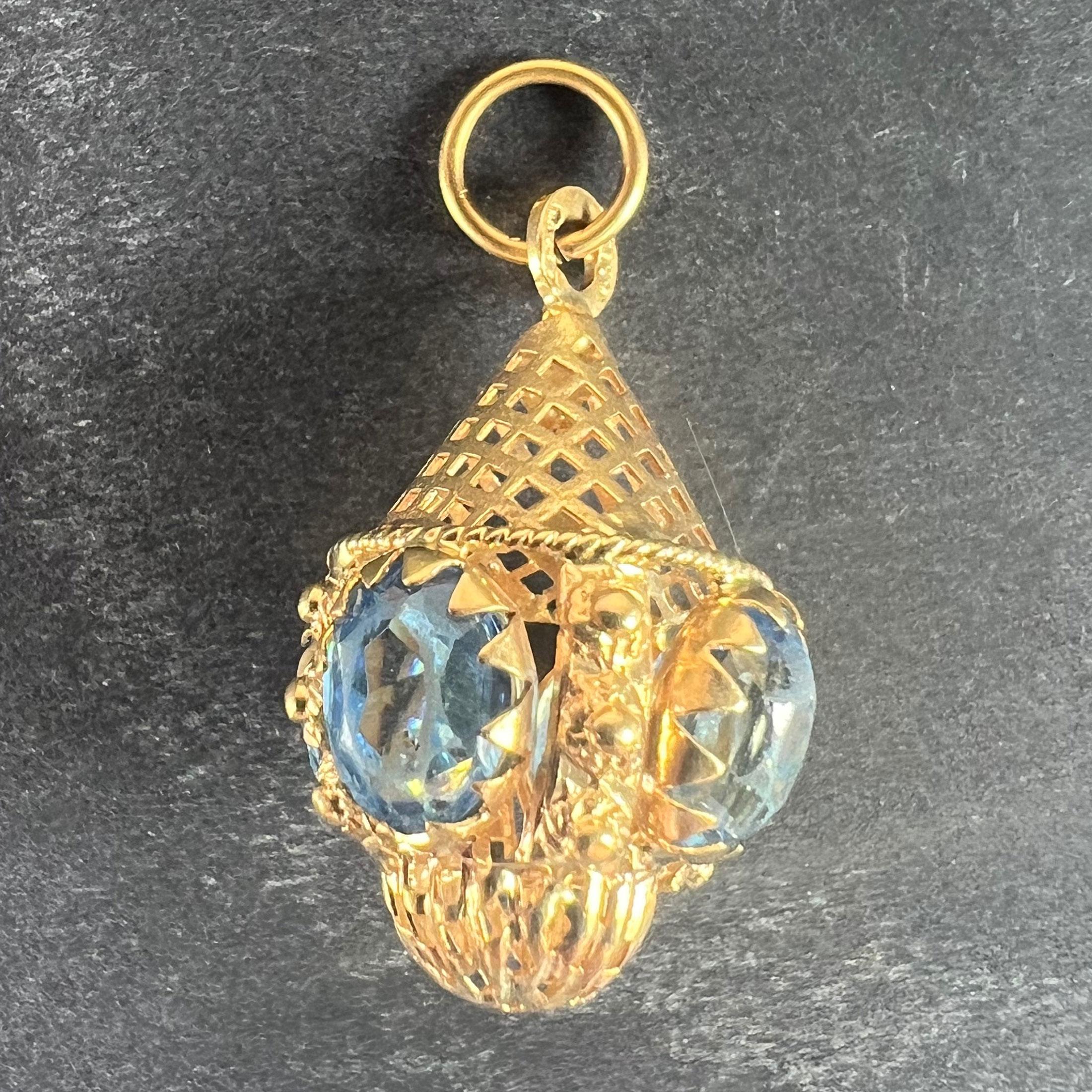 Un ciondolo in oro giallo 18 carati (18K) disegnato come un ciondolo etrusco traforato e incastonato con pasta blu. Il timbro 750 indica oro a 18 carati e manifattura italiana.

Dimensioni: 2,9 x 1,8 x 1,8 cm (escluso l'anello di sospensione)
Peso: