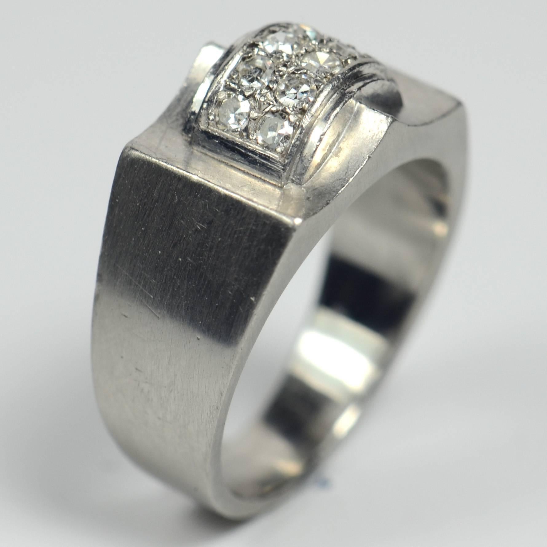 A Modernist French platinum and diamond ring with a stylish bridge form to a curved architectural motif, pave-set with 10 single-cut diamonds with a total weight of approximately 0.30 carats. The platinum has a brushed finish, giving a subtle gleam