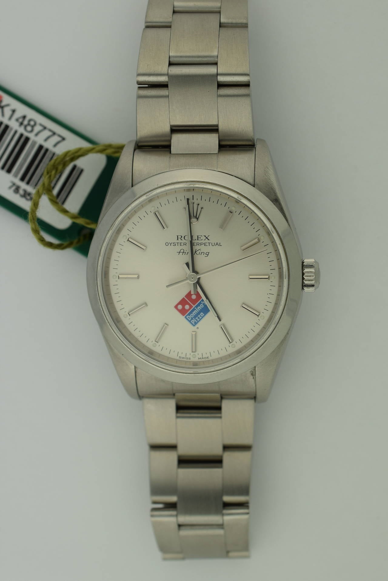 Rolex Oyster perpetual Airking automatic, with Domino's Pizza insignia on dial.  
Circa 2001-2002. K series. Excellent condition and accompanied by both the original Rolex guarantee card and box. .34 mm case diameter. Rolex Oyster stainless steel