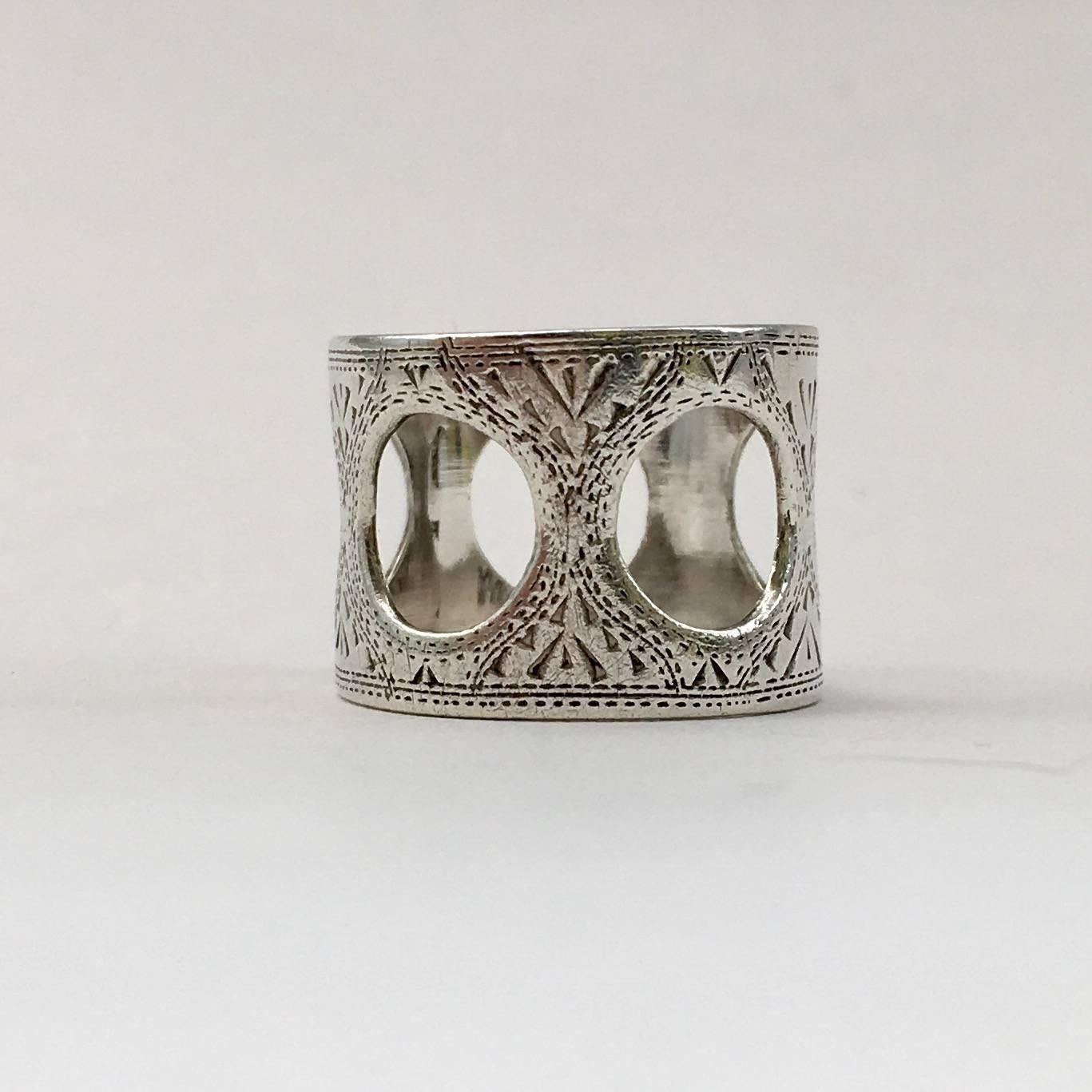 A lovely example of Siam silver, this vintage ring is stylish and wearable. It has unusual circular cutouts and delicate engraving. The band has a depth of 1.8cm and the circles have a diameter of 0.8cm. 

Size: UK N, US 6 1/2 