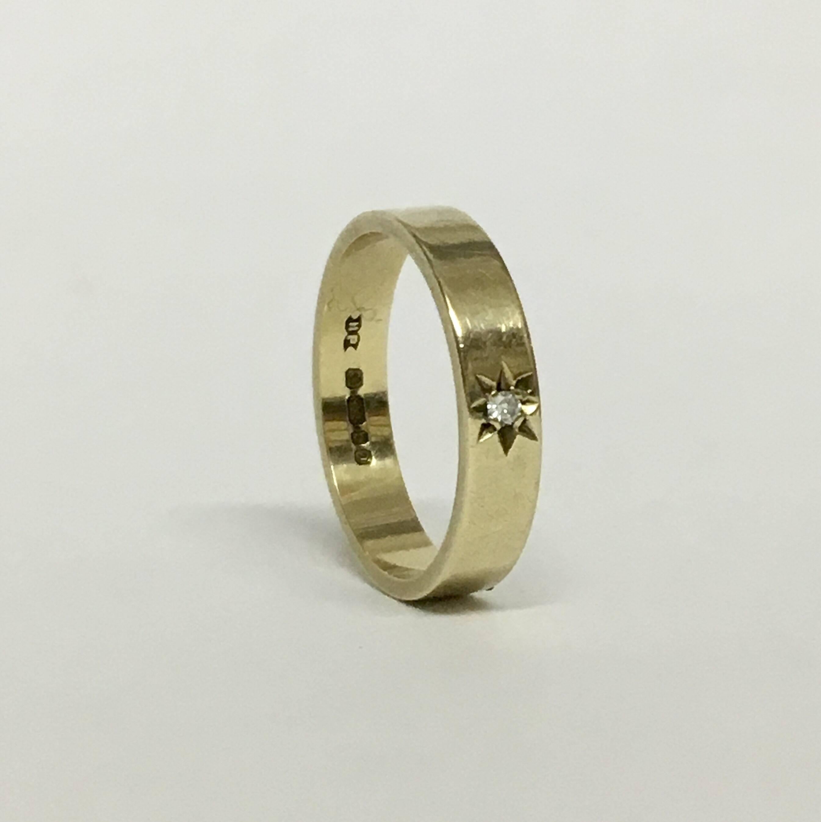 This simple 9ct gold band ring has been stylishly embellished with a dainty diamond solitaire set within a twinkling eight-point star. It has a cool, understated elegance when worn alone, or makes the perfect stacking ring to wear alongside other