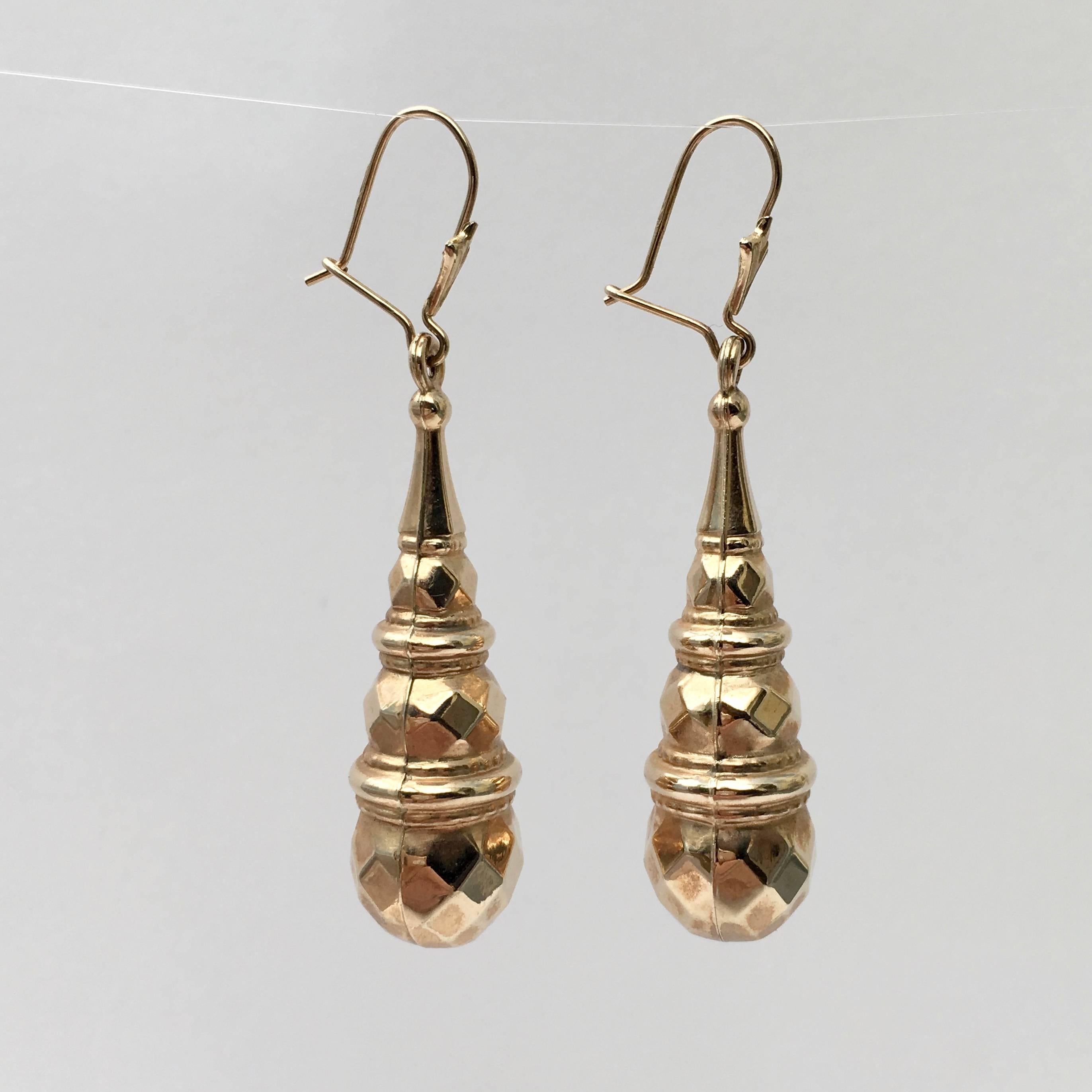 A striking pair of 9ct gold torpedo-shaped drop earrings. The moulded drops are hollow, making them lightweight and extremely wearable. The style has an air of the mid-Victorian era about it, though we think they are probably later. The drops
