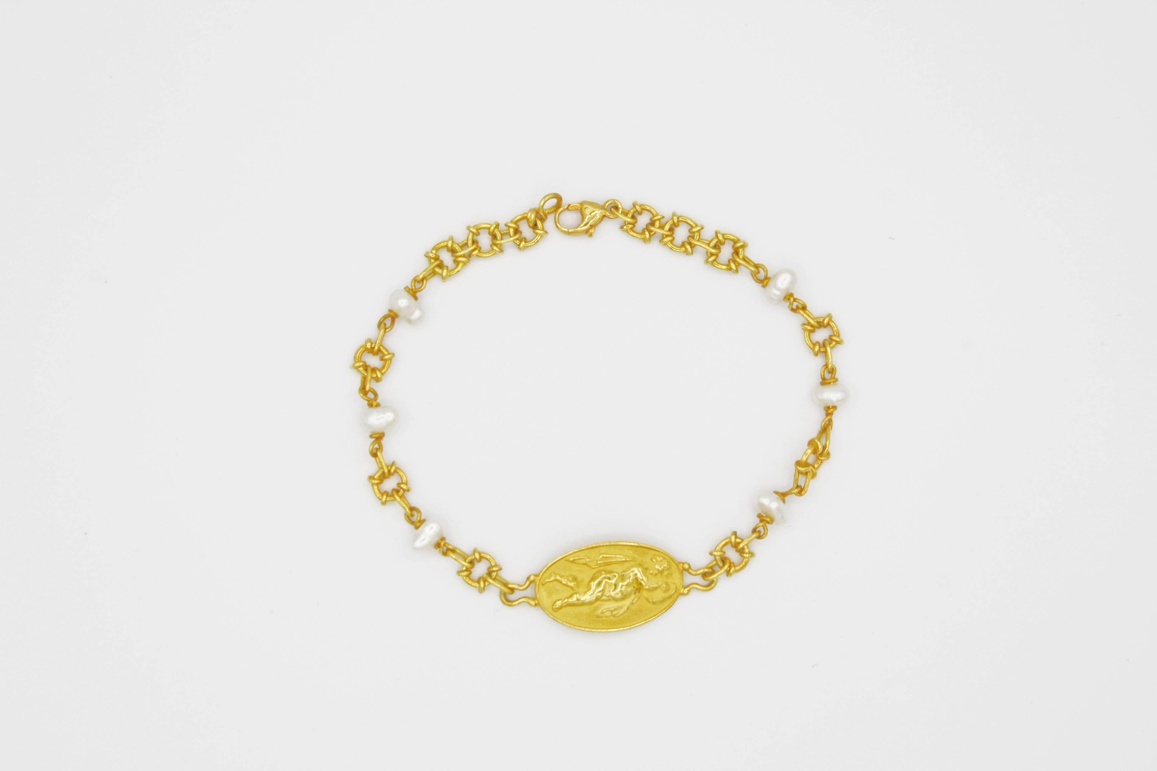 This ethereal 18k gold link bracelet is a piece from Renato Cipullo's Romantica Collection.  The bracelet is comprised of a cupid medallion joined with elaborate loops as well as petite freshwater pearls.