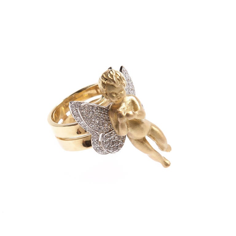 Sculptural Renato Cipullo Yellow 18kt gold Cupid ring with 18kt white gold Pave wings and beautiful spiral design shank.
Size 6 1/2
Gold Cupid measures 1.31 inches long
Wings measure .80 inches wide
Total carat weight 1.90