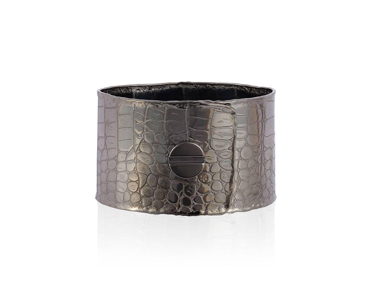 Alligator print cuff with screw motif
Hidden closure
Sterling silver with Black rhodium plate resulting in a beautiful grey patina.
Width 28mm
Diameter 61mm X 48mm
Weight 36dwt