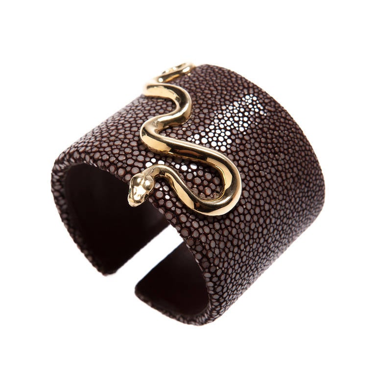 A Renato Cipullo cuff of genuine chocolate colored Shagreen and leather interior, featuring an 18kt yellow gold snake with emerald eyes.  A beautiful piece from Cipullo's shagreen collection.